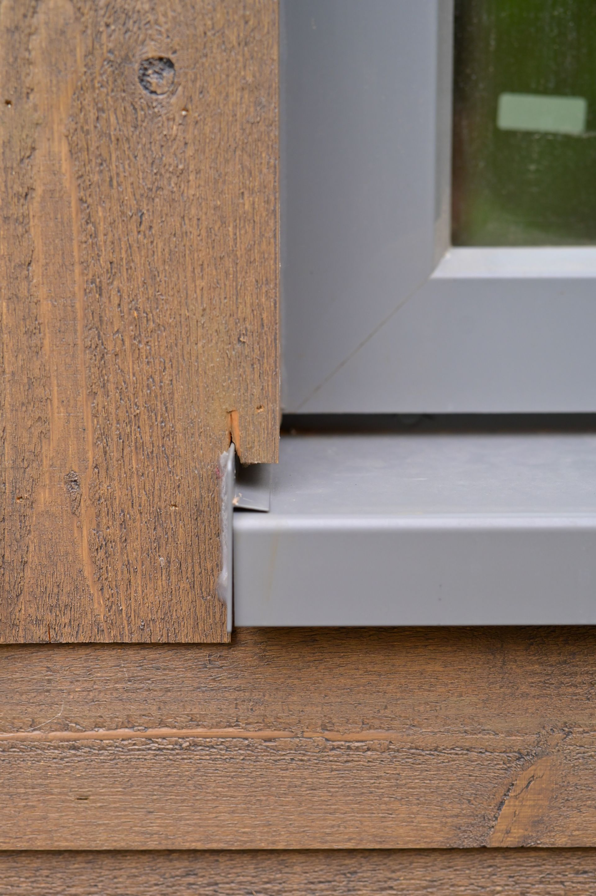 A close up of a window sill on a wooden wall.