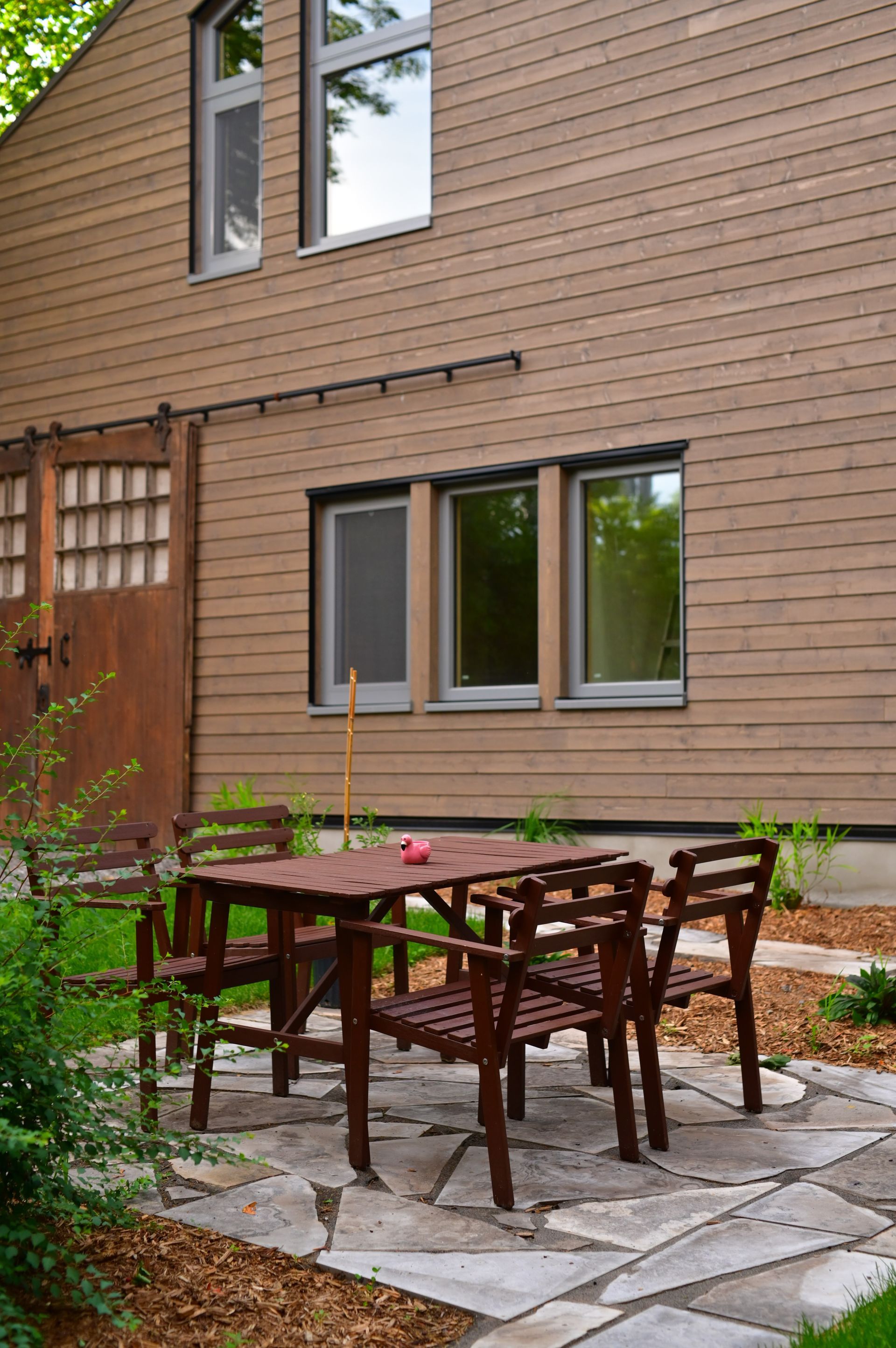 A patio with a table and chairs in front of a house.