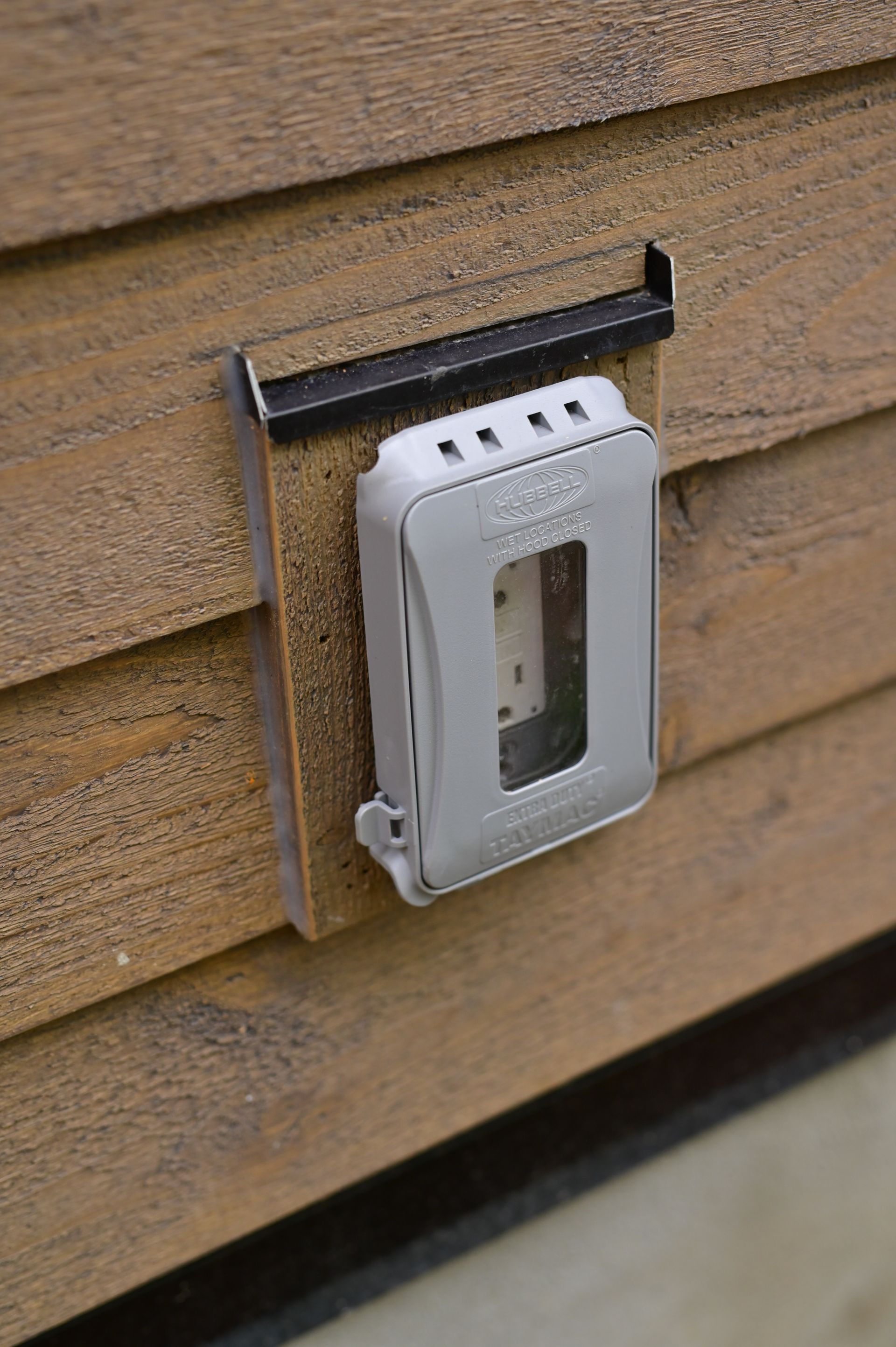 A close up of a light switch on a wooden wall.