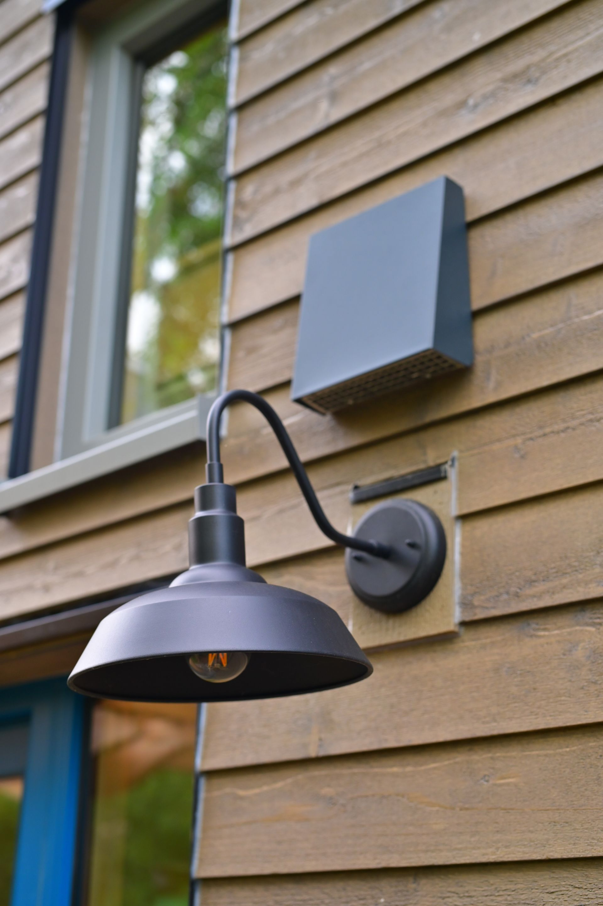 A light on the side of a wooden house