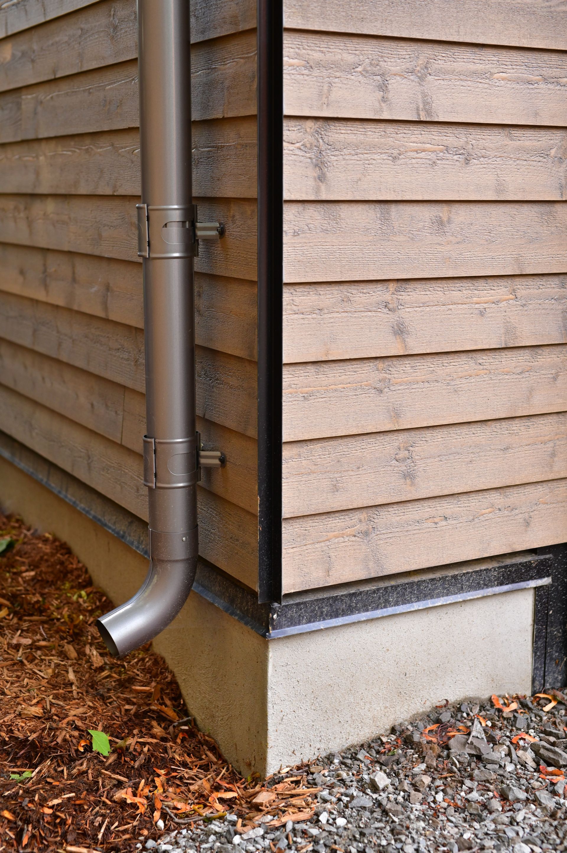 A close up of a gutter on the side of a house.