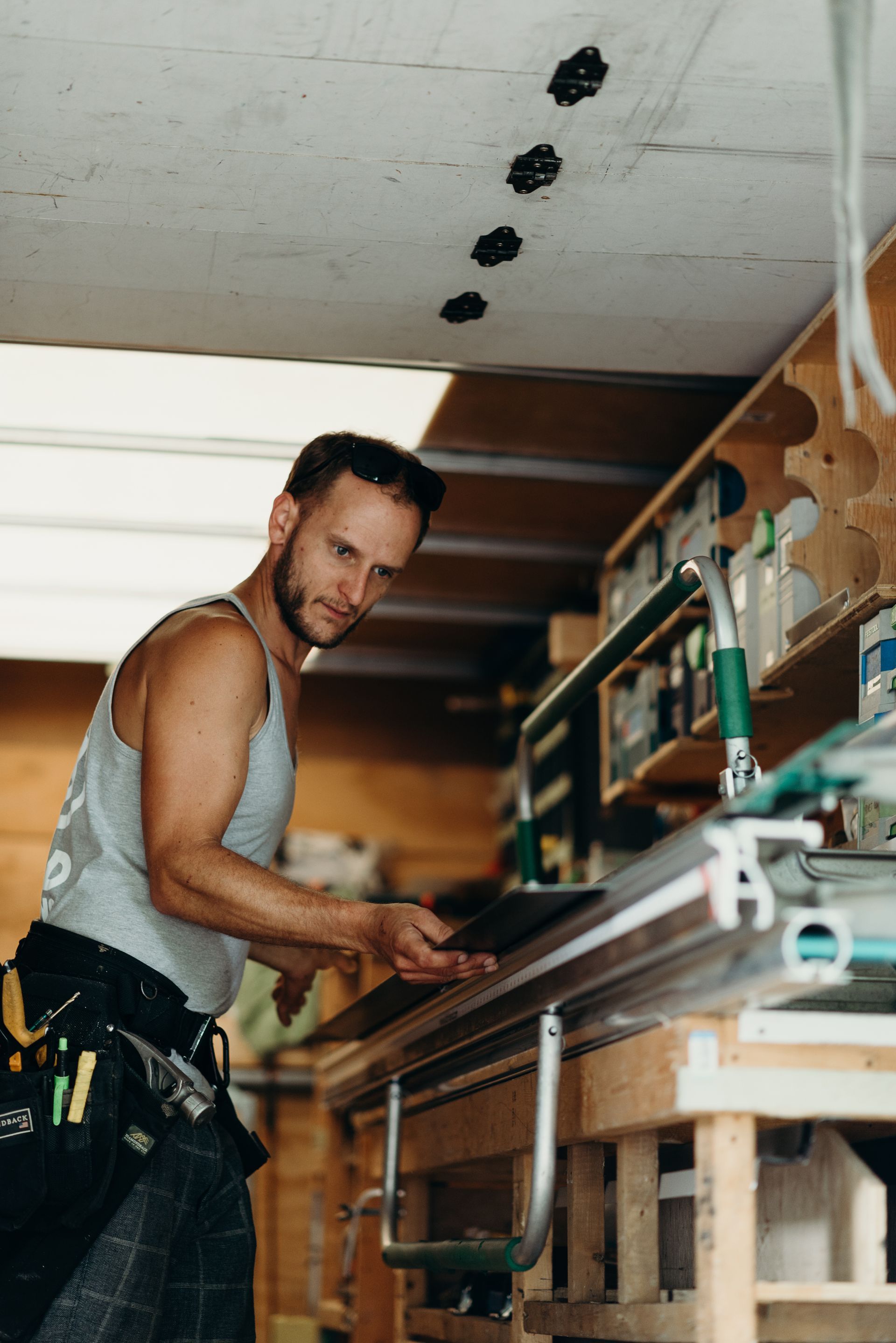 A man is working on a piece of wood in a workshop.