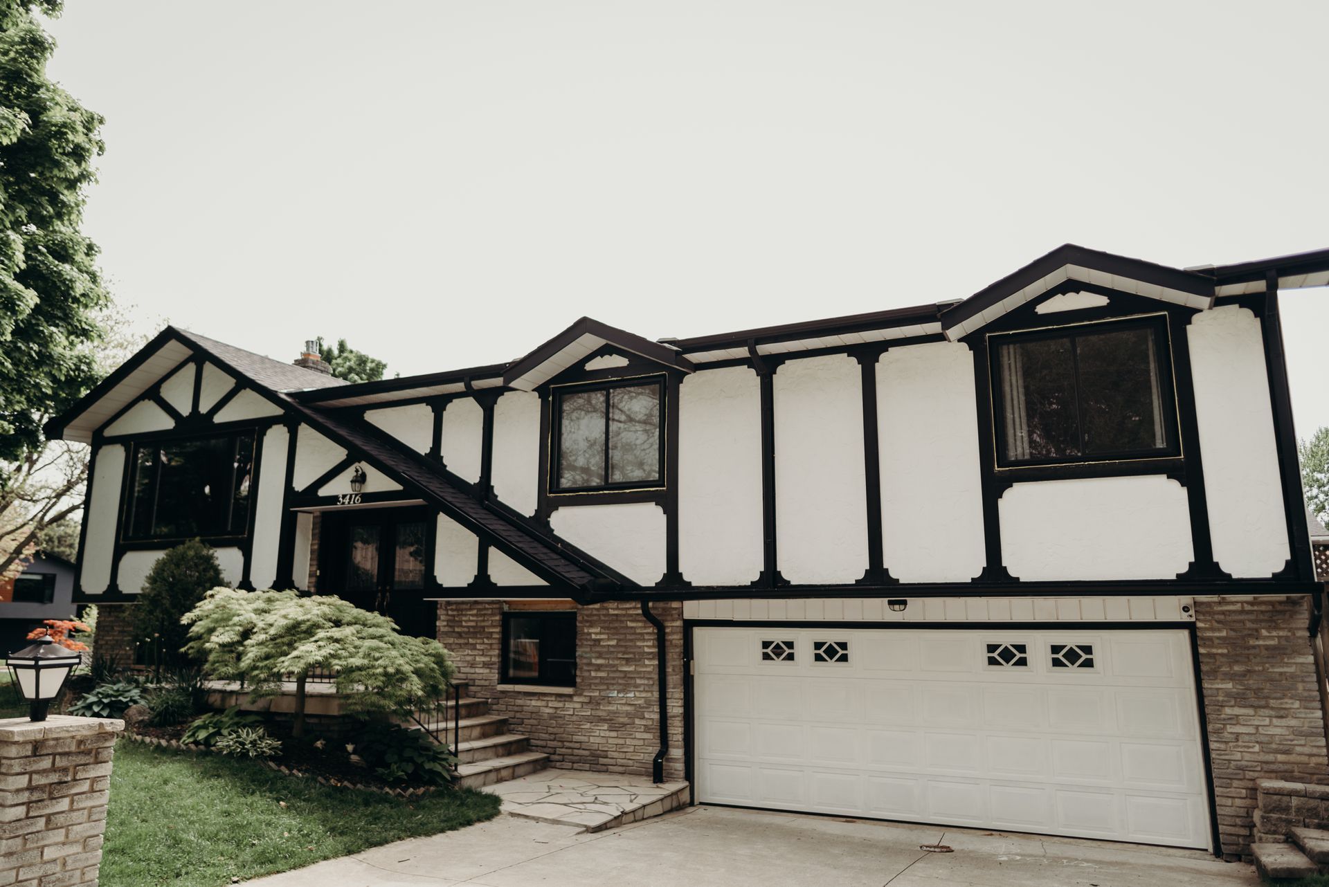 A black and white house with a white garage door