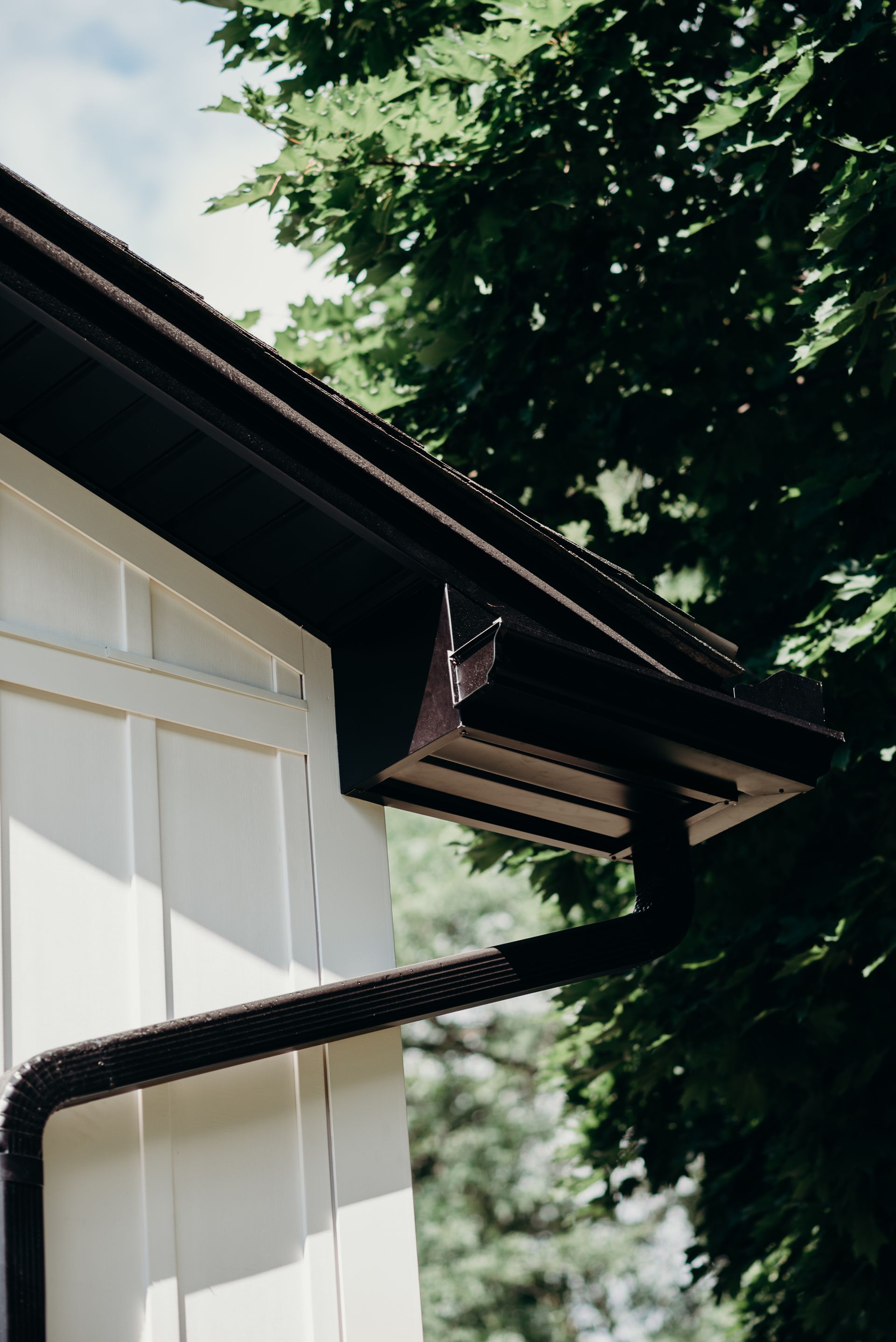 A close up of a gutter on the side of a house