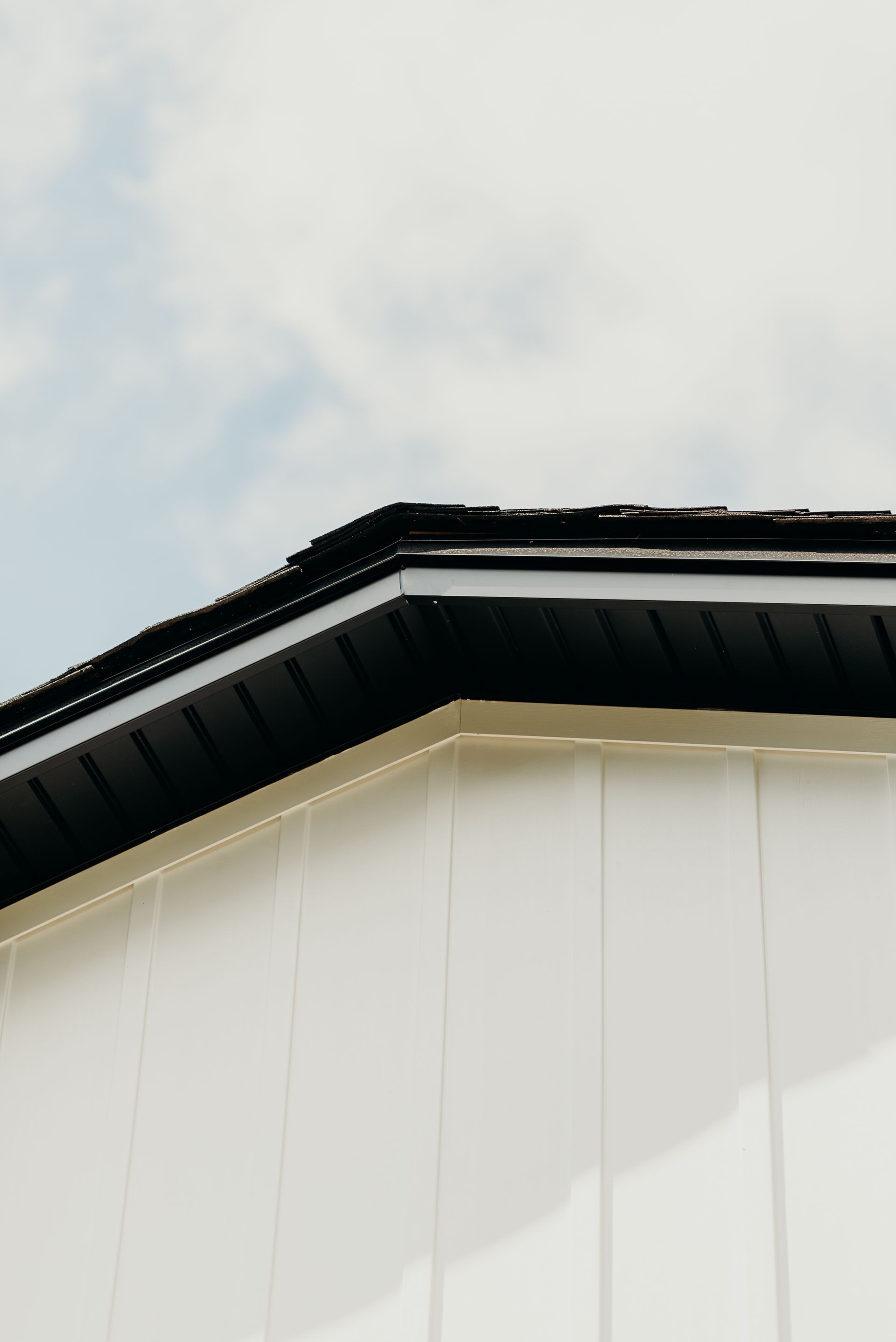 A white building with a black gutter on the roof.