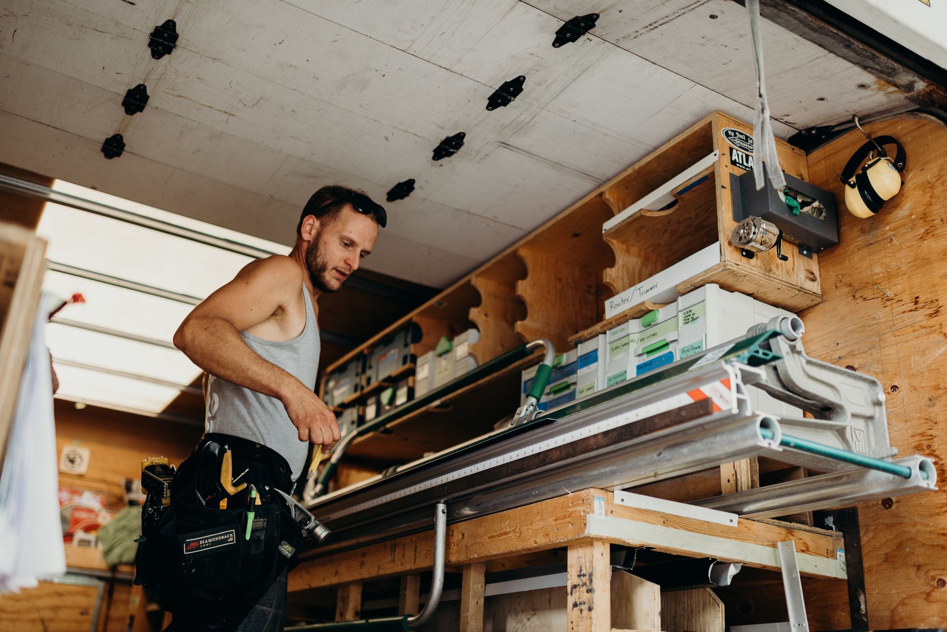 A man is working on a piece of wood in a truck.
