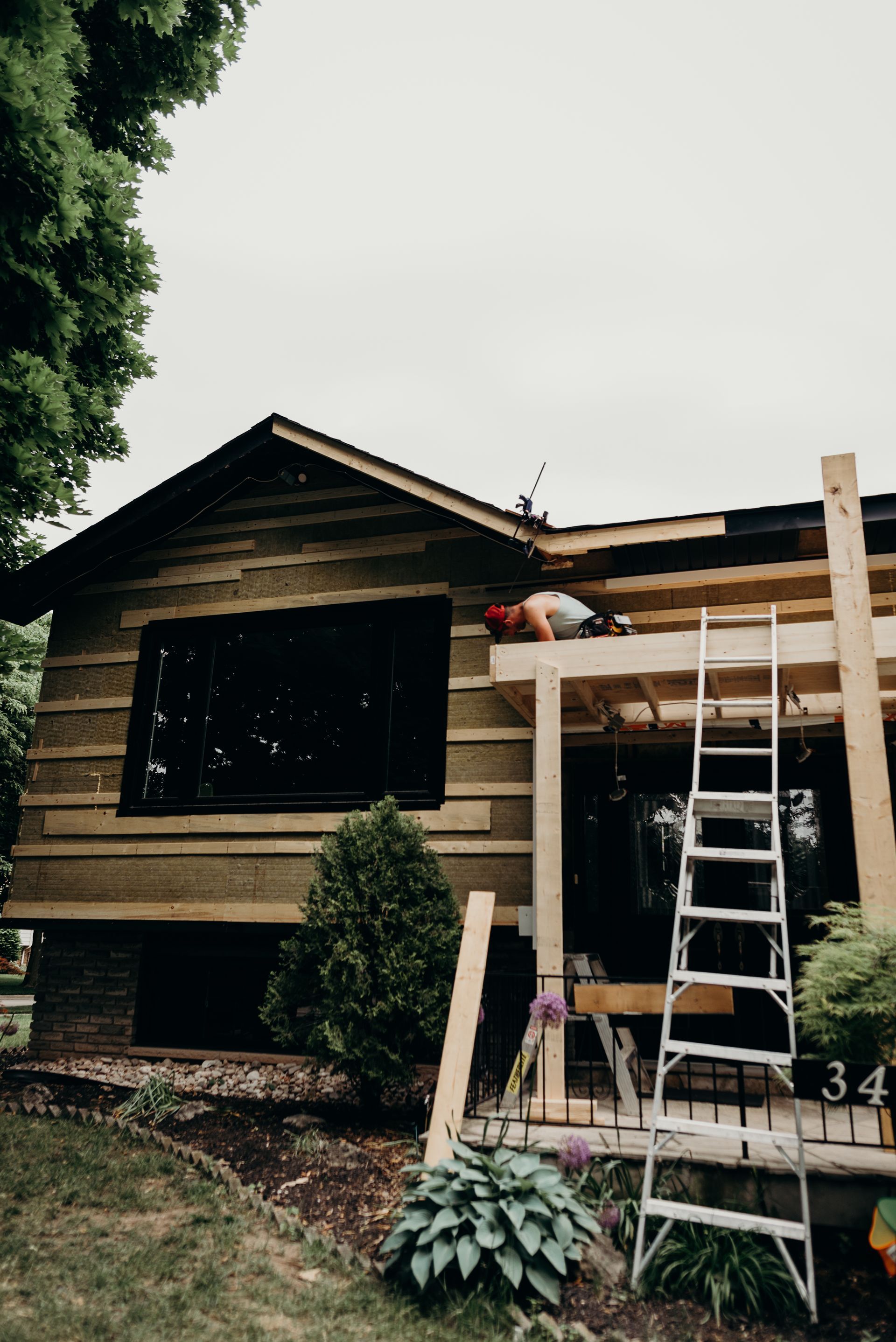 A man is working on the roof of a wooden house.