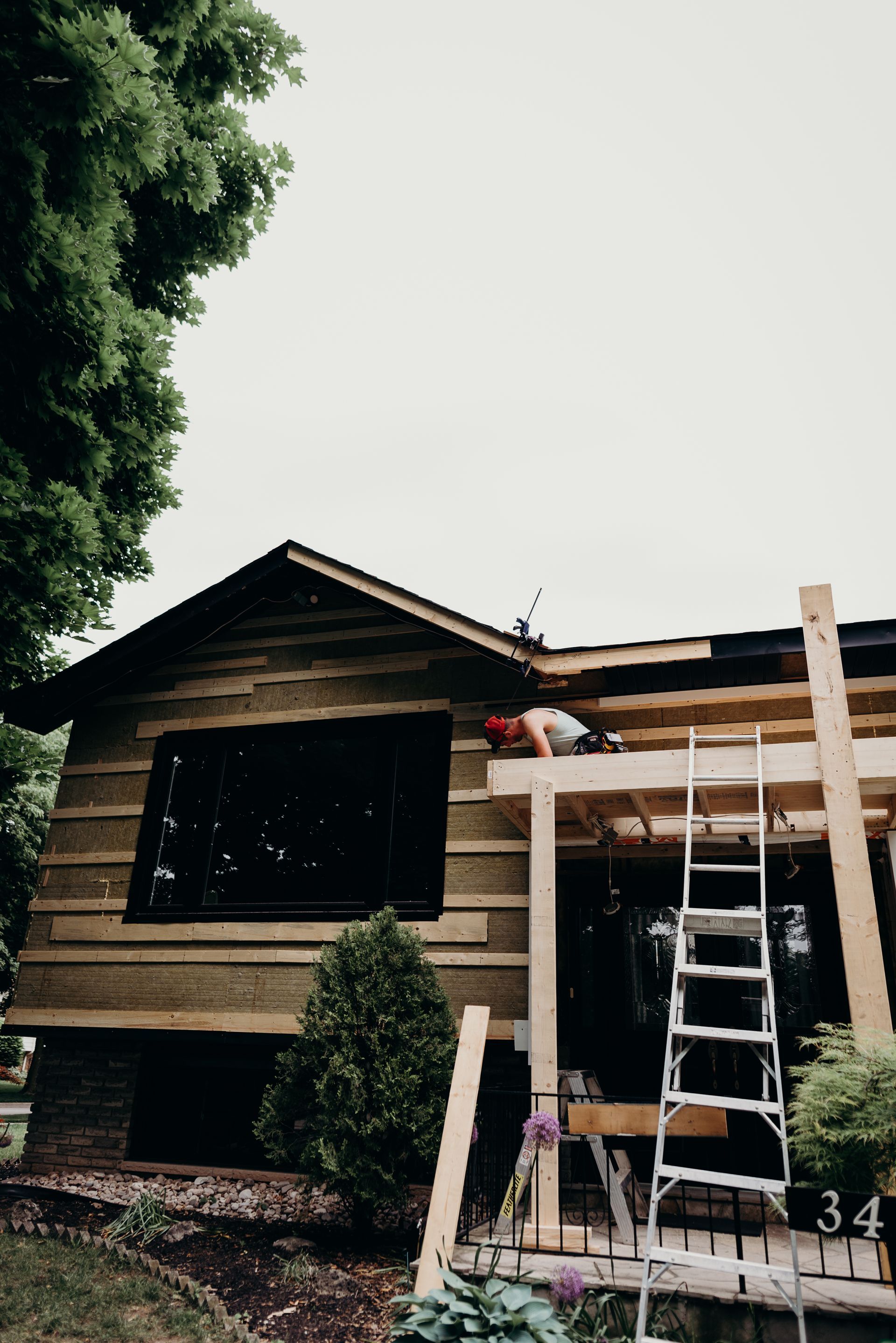 A man is working on the roof of a wooden house.