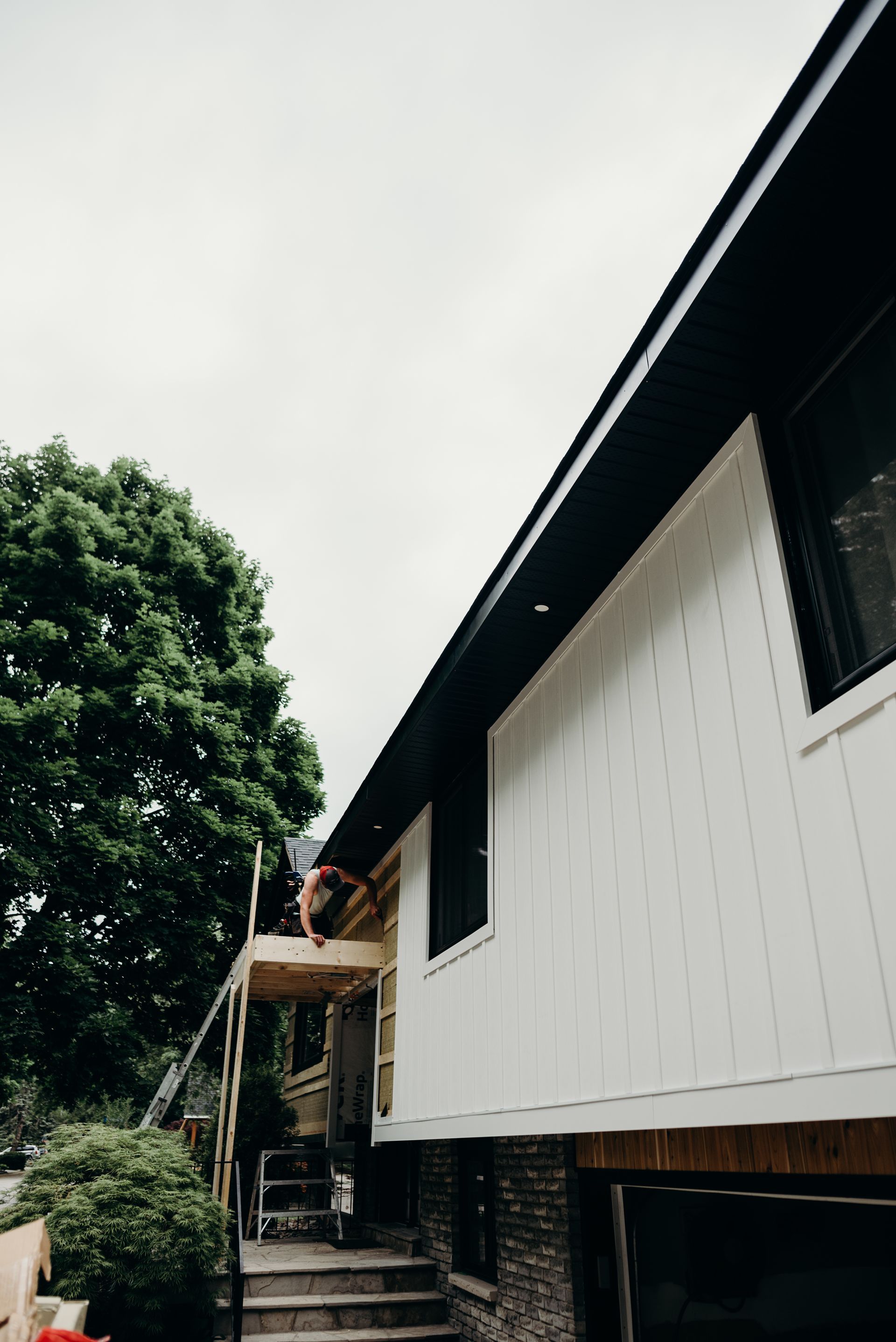 A man is working on the roof of a house.