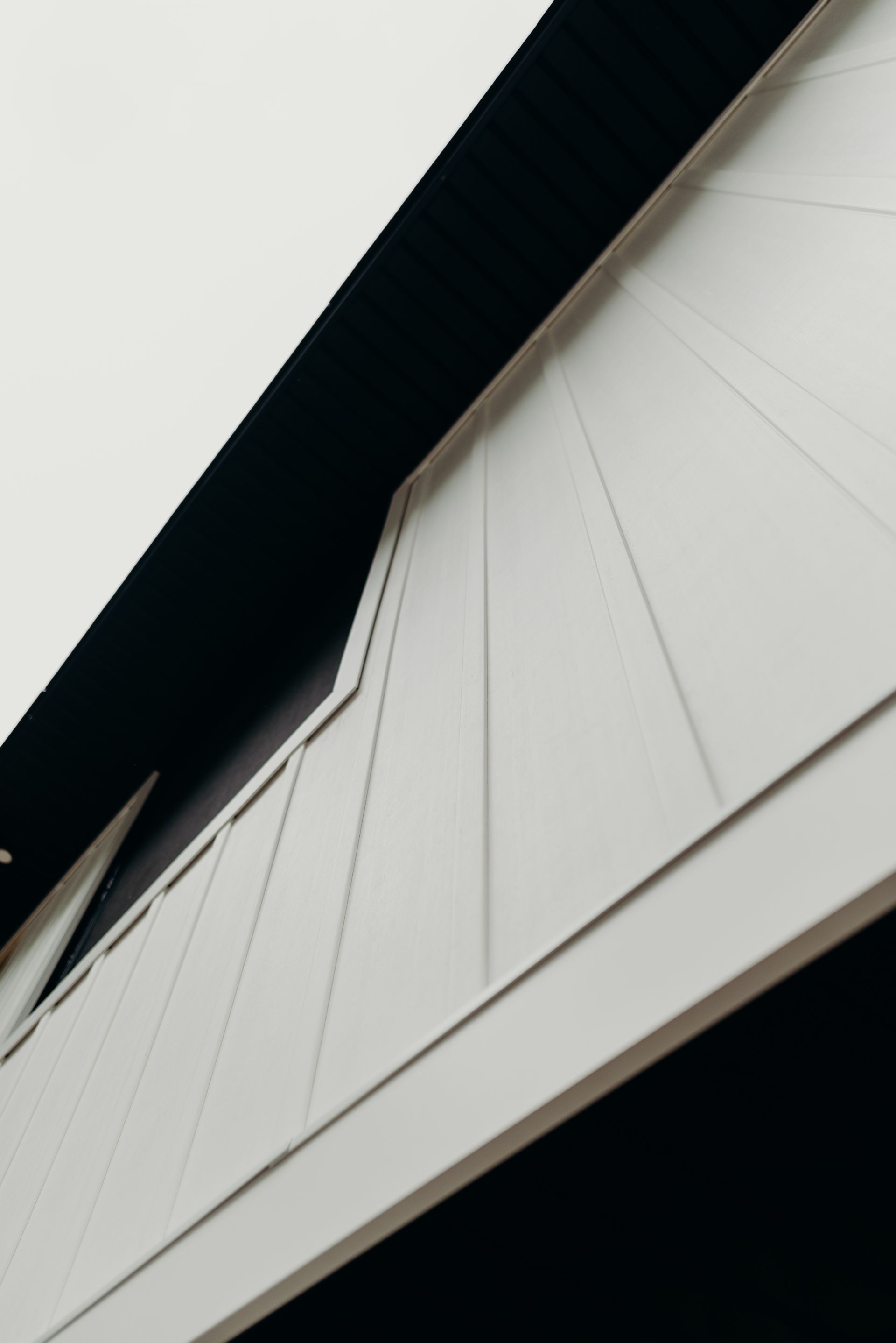 Looking up at a white building with a black roof