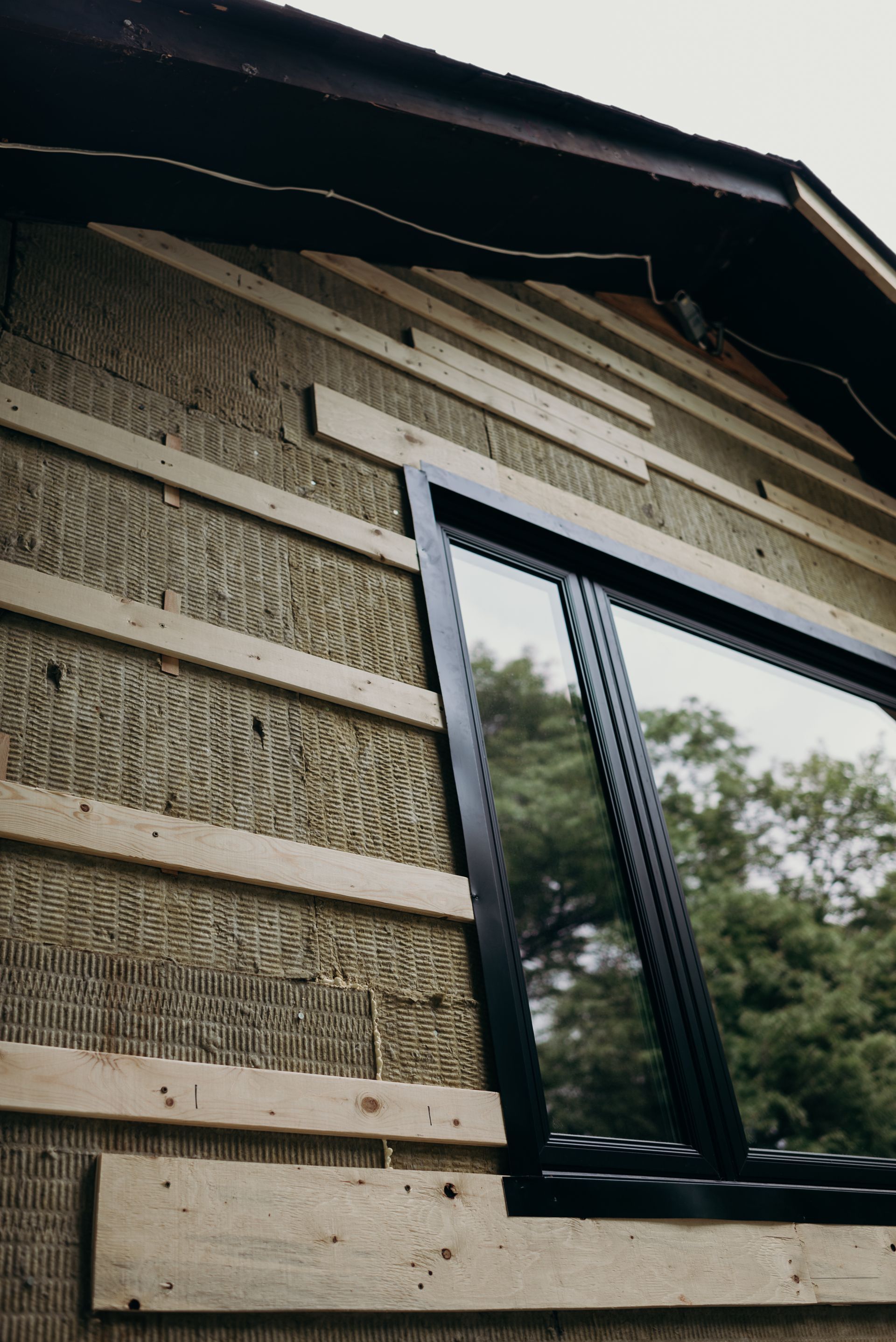 A window is being installed on the side of a building.