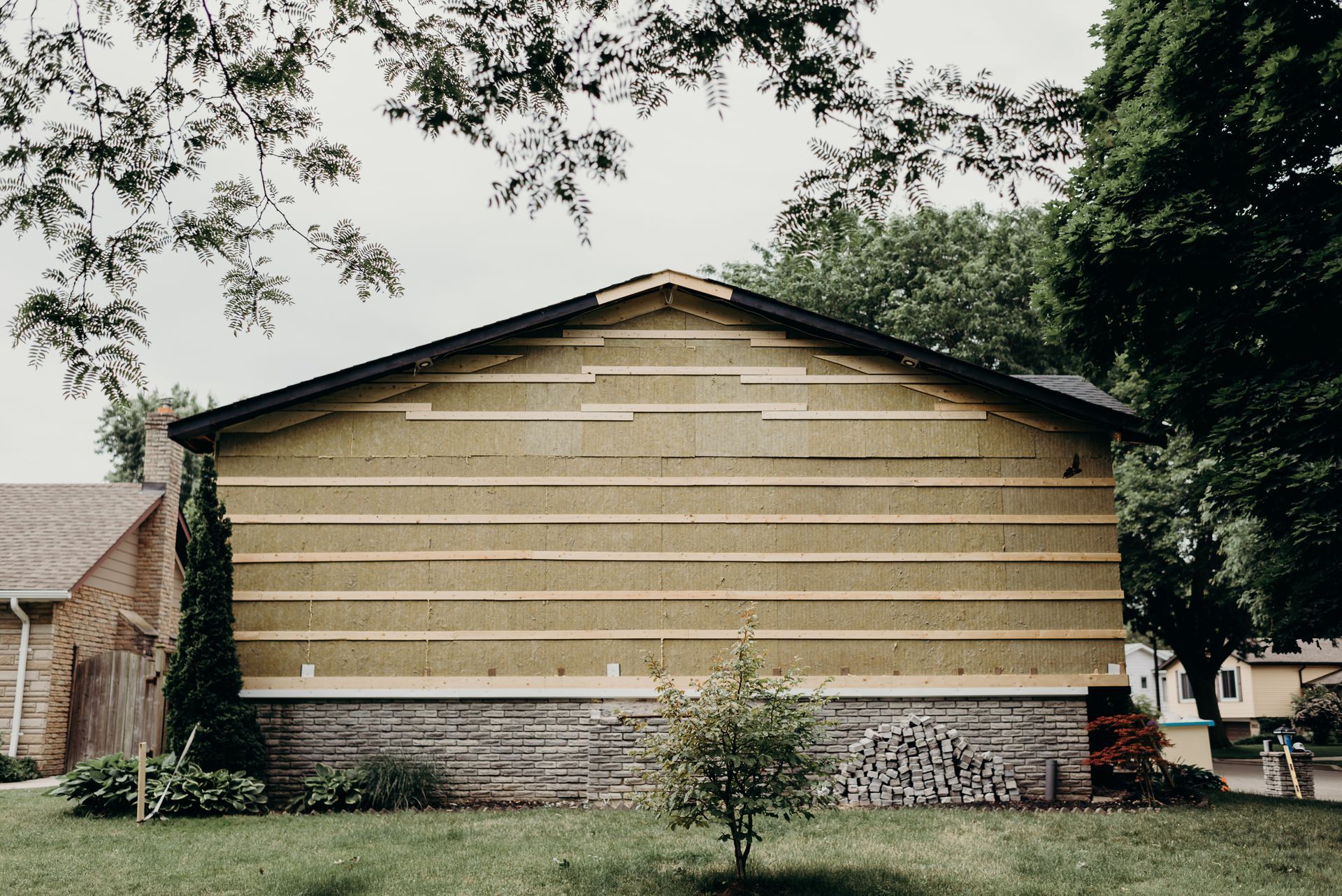 A house with a lot of wood on the side of it is being built.