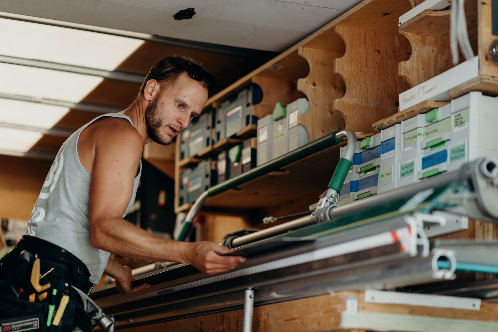 A man is working on a piece of wood in a workshop.