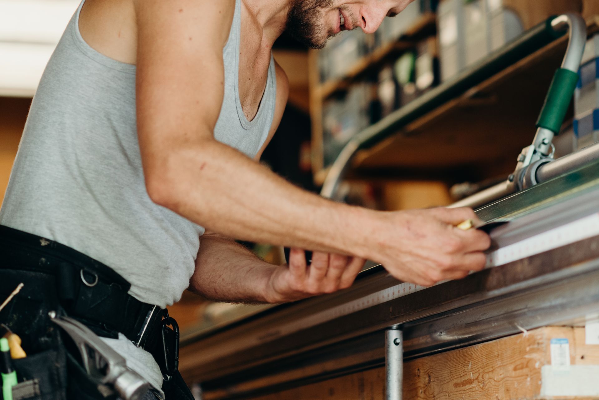 A man is working on a piece of metal in a workshop.