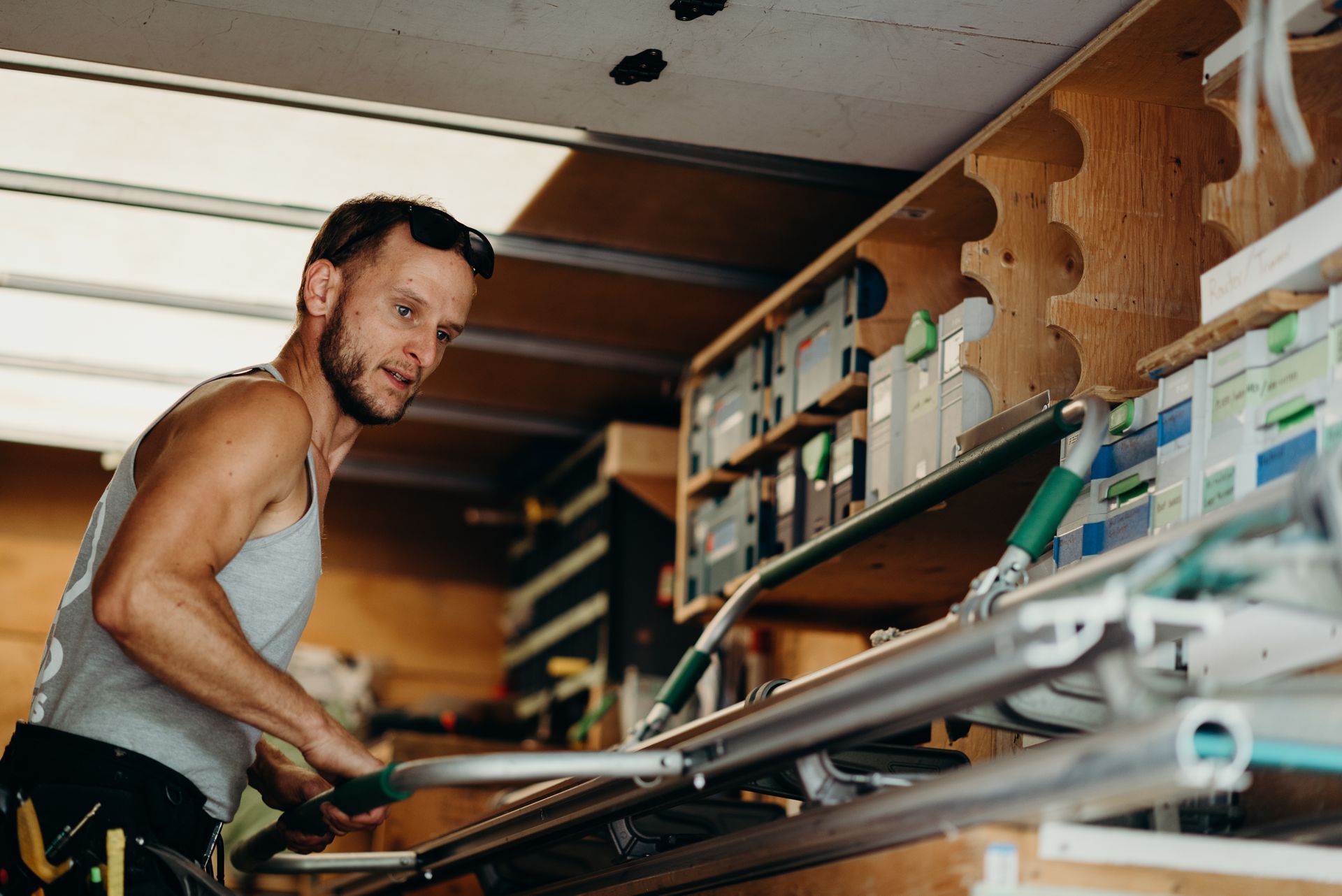 A man is working on a piece of wood in a truck.