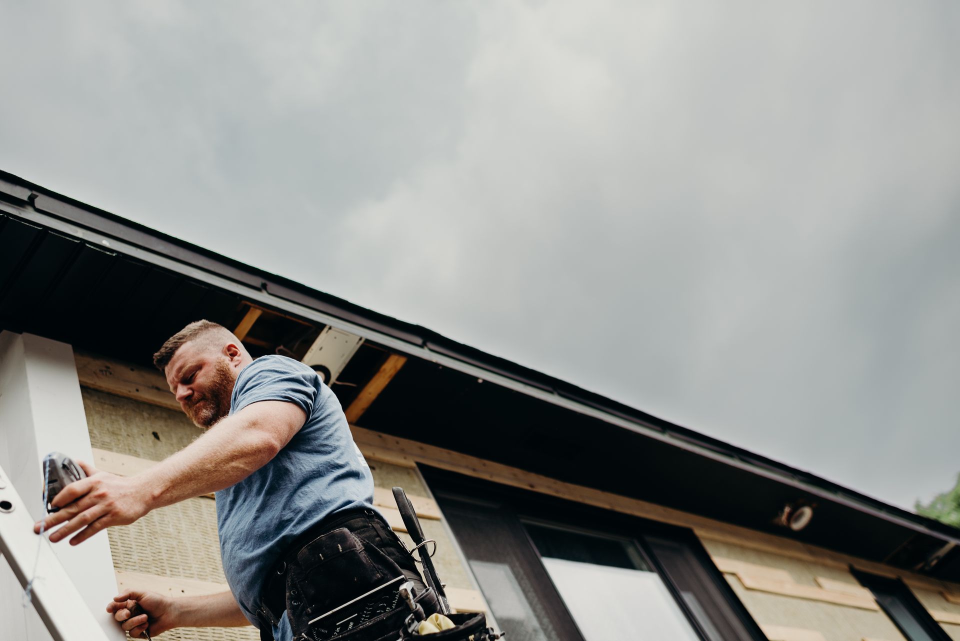 A man is working on the side of a house.