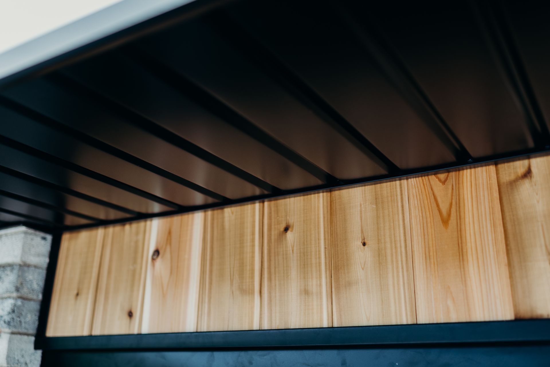 A close up of a wooden wall with a black ceiling.