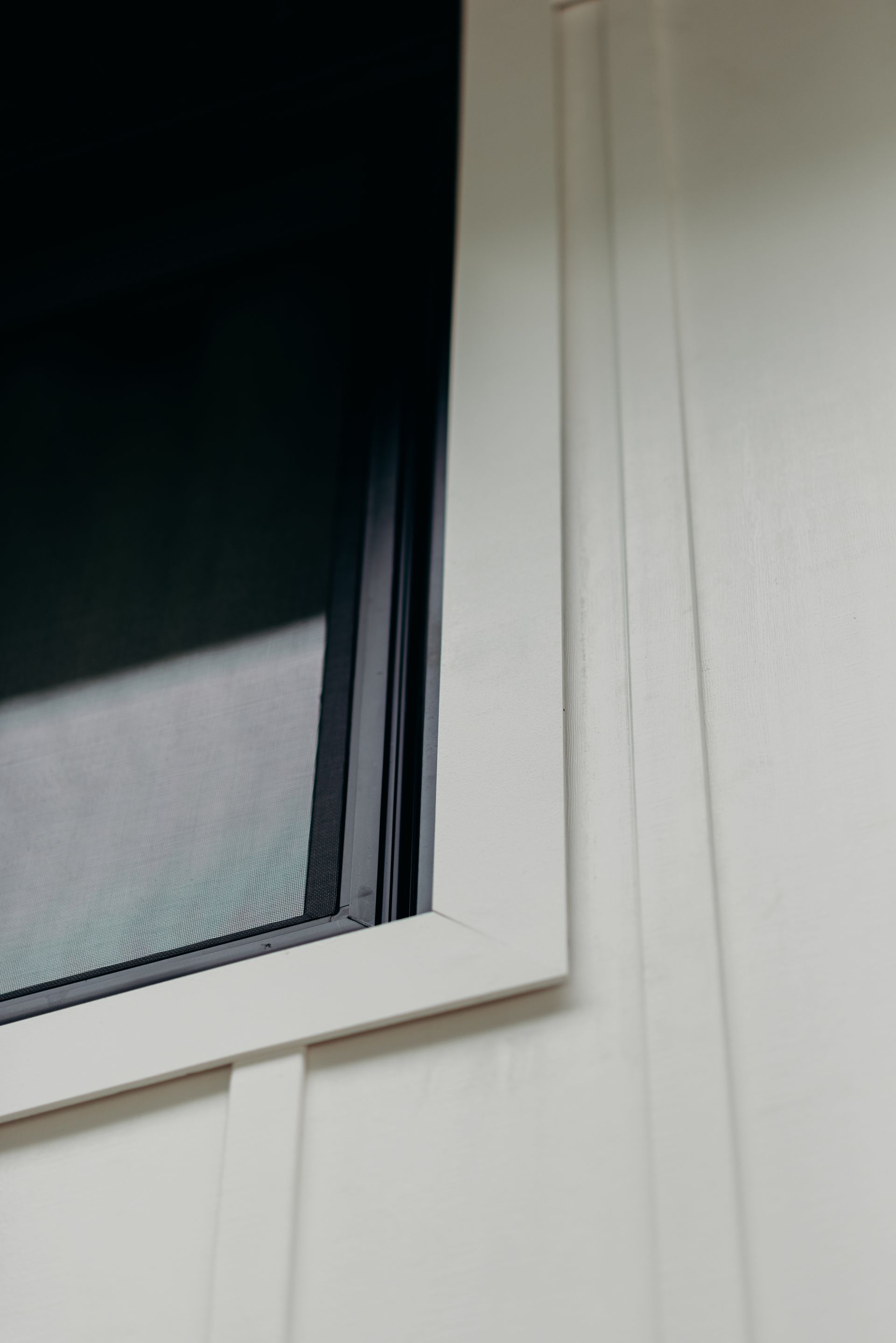 A close up of a window on a white wall
