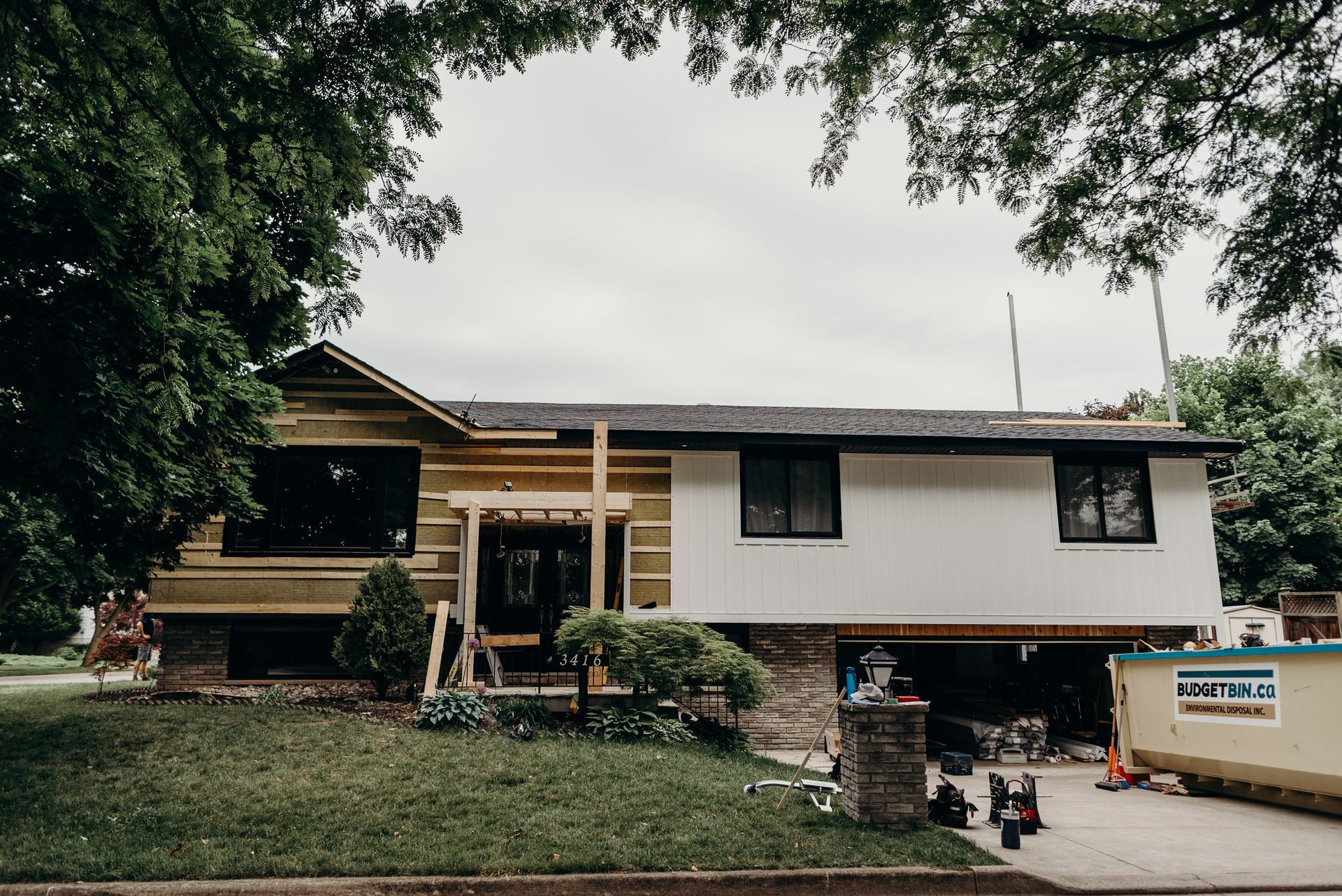 A house is being remodeled with a lot of trees in the background.