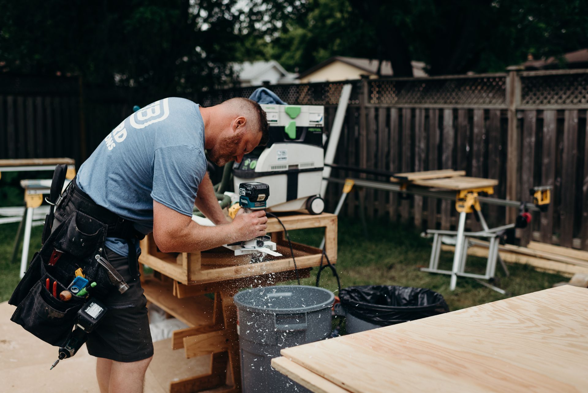 A man is cutting a piece of wood with a circular saw.