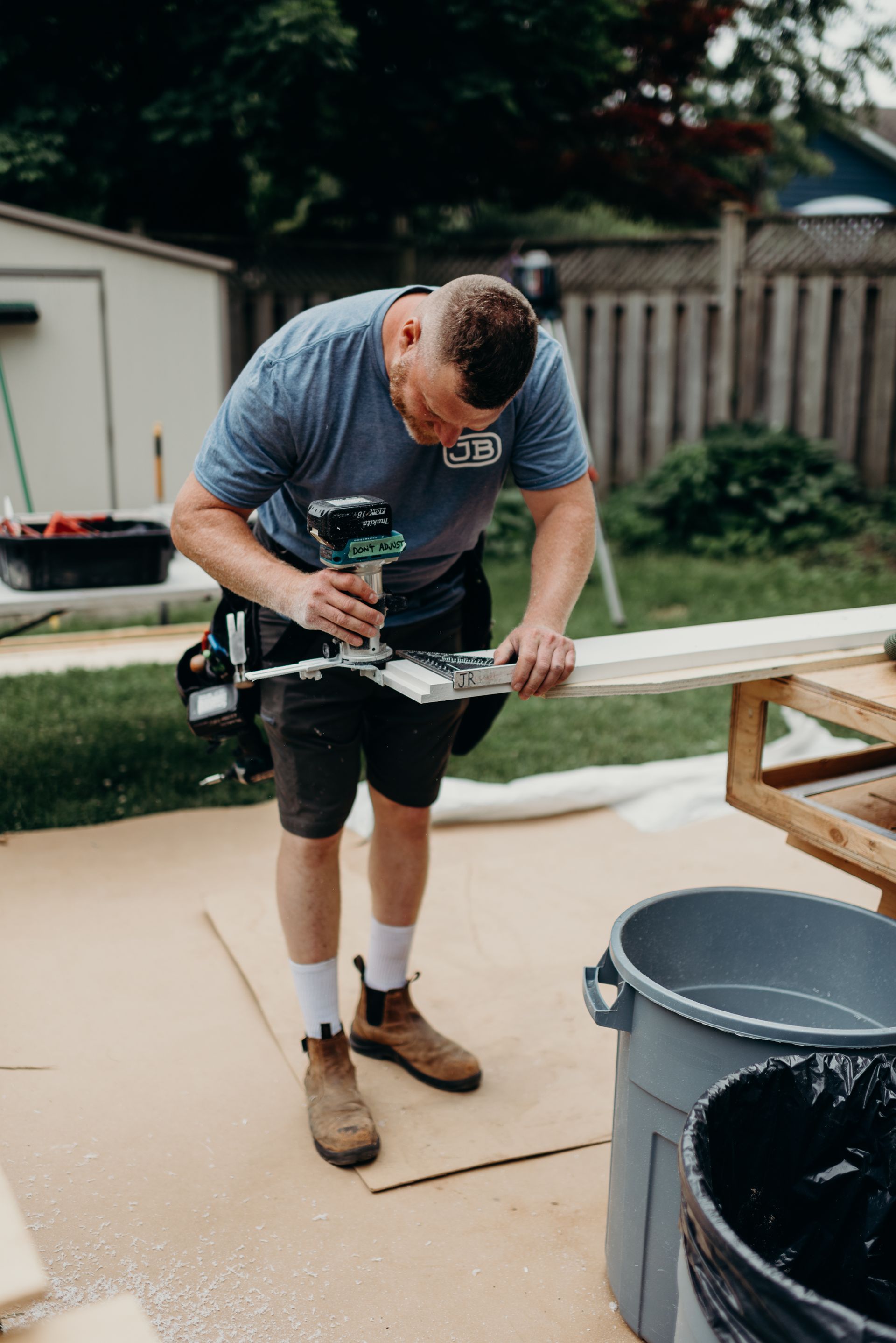 A man is using a drill to cut a piece of wood.