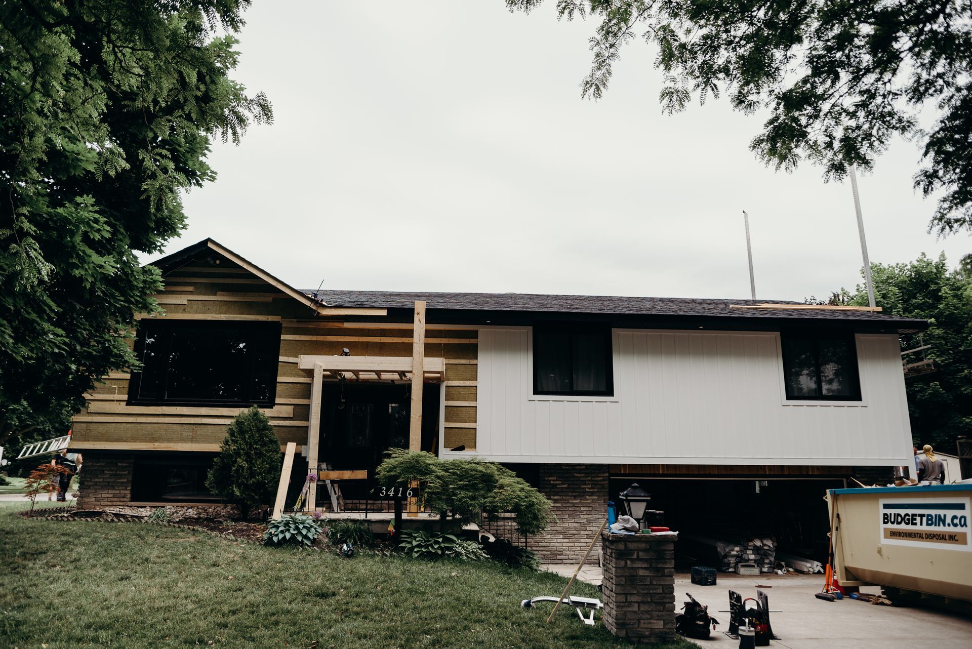 A house is being remodeled with a lot of trees in the background.