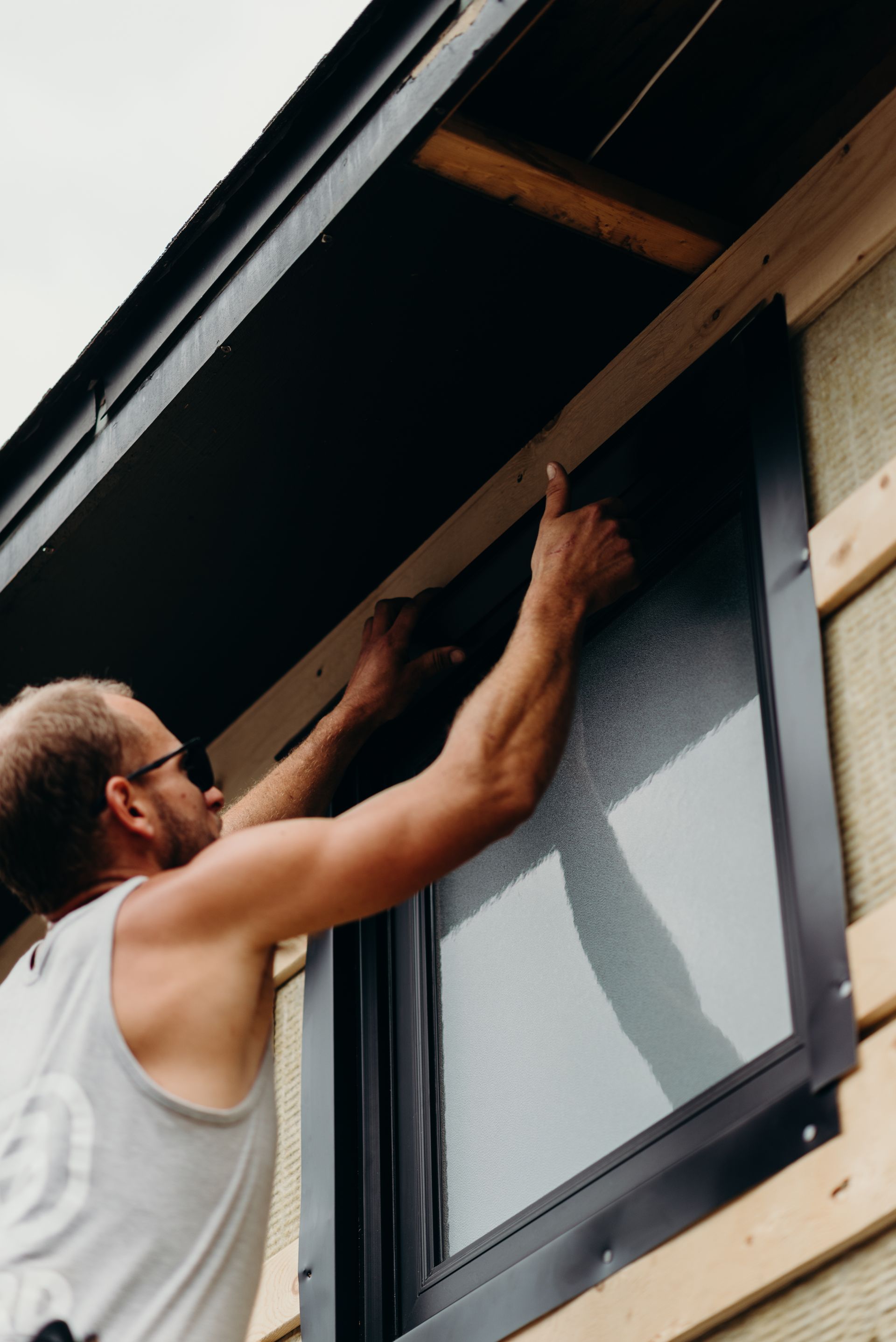 A man is fixing a window on a house