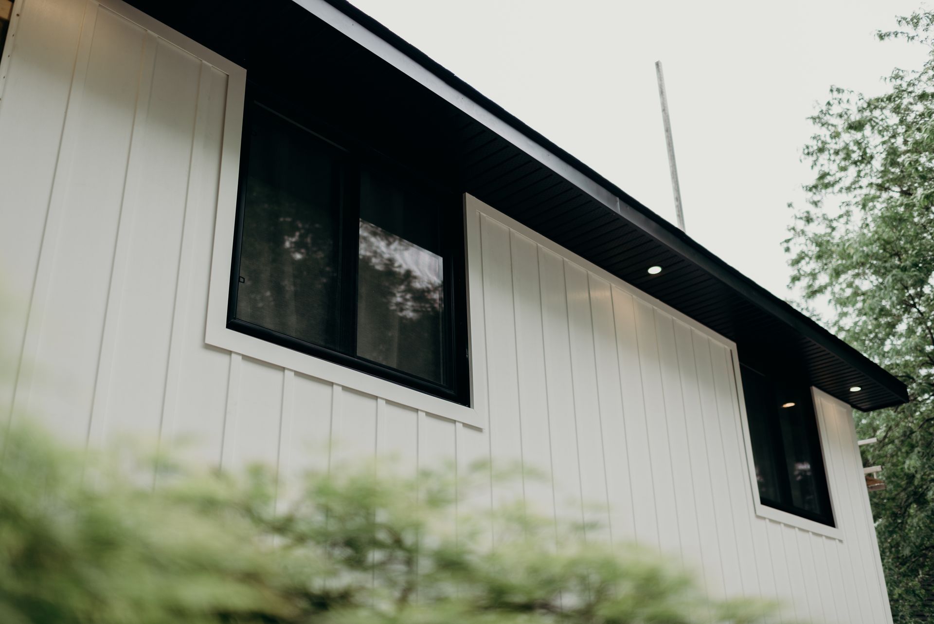 A white house with black windows and a black roof.