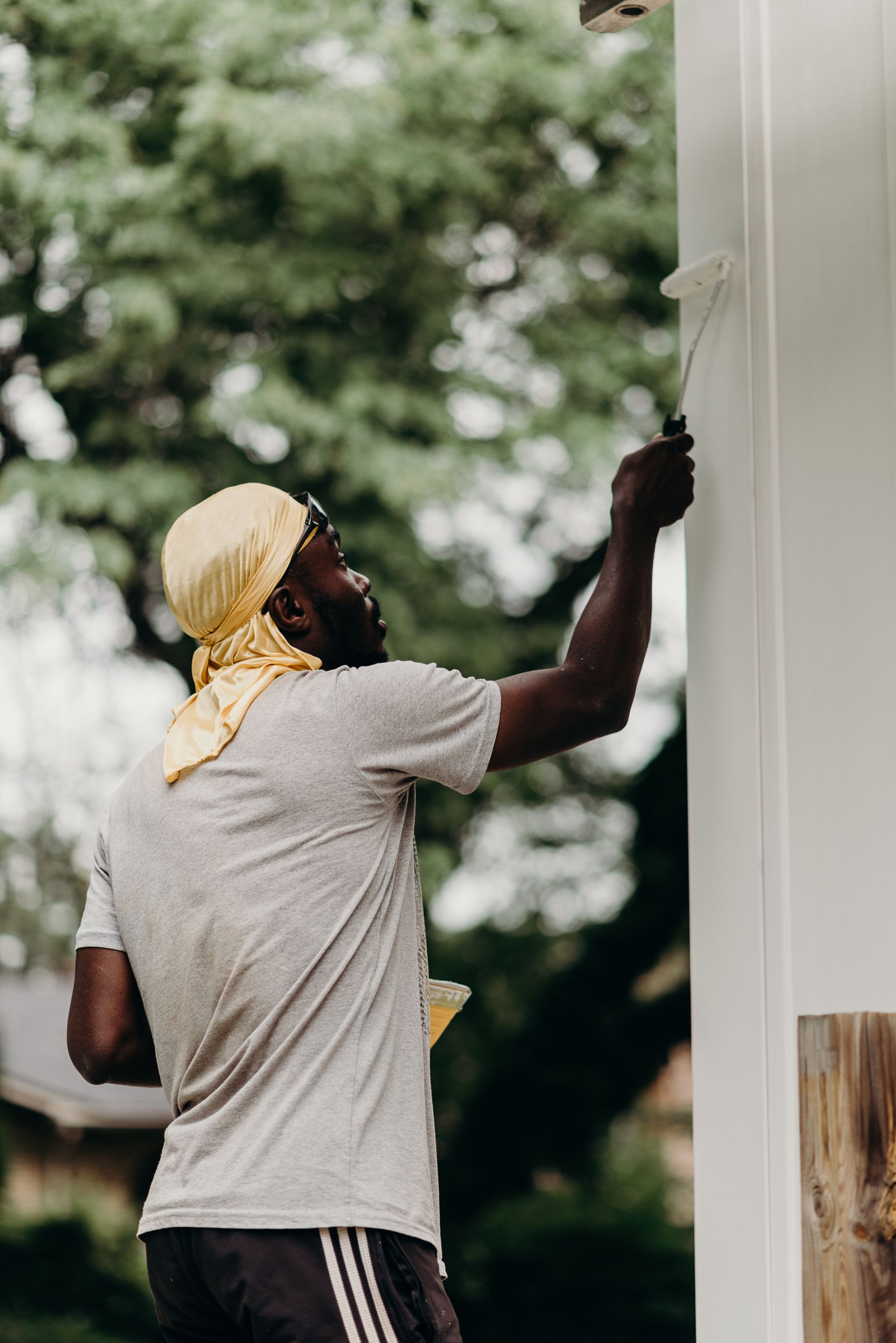 A man is painting a white wall with a brush.
