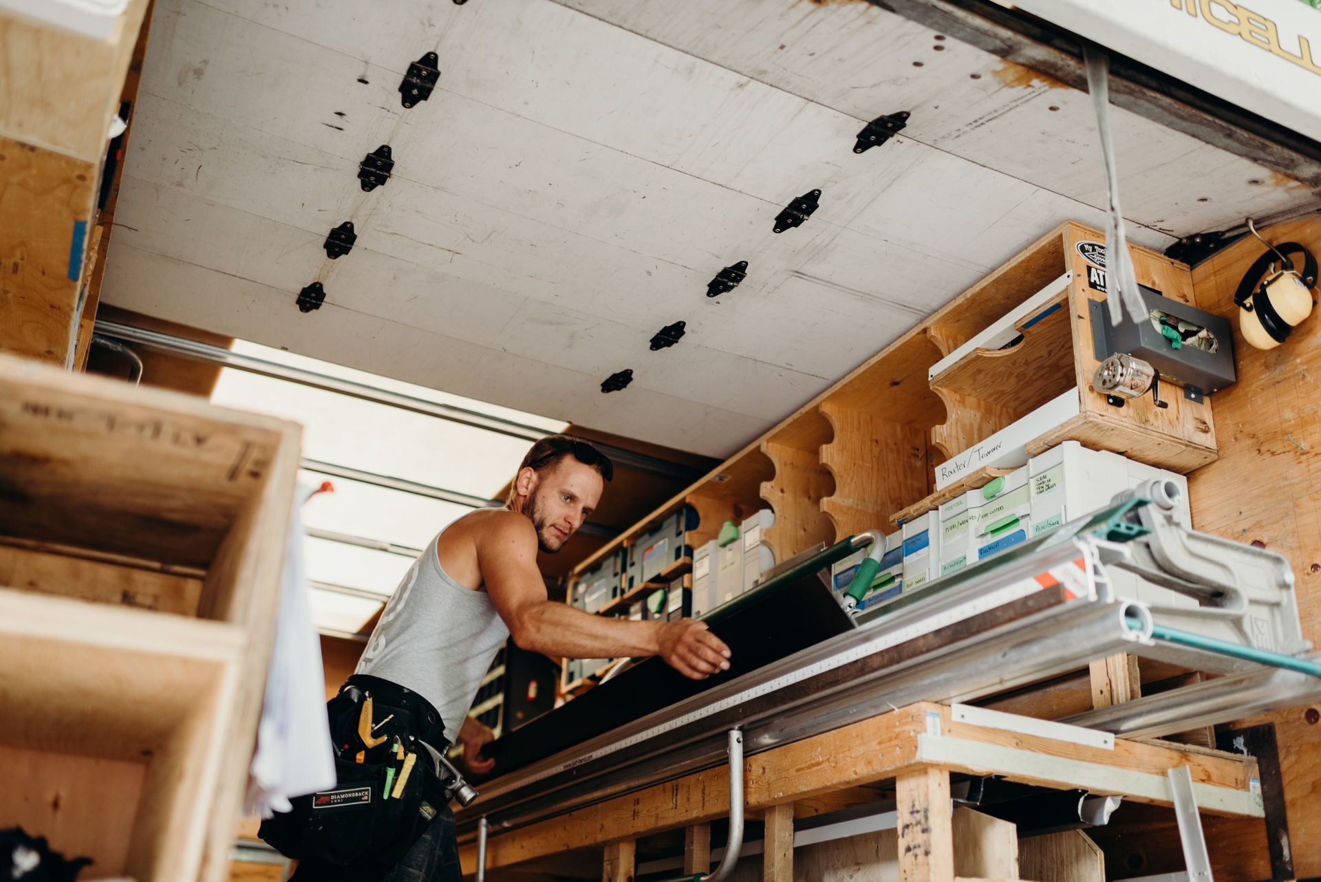 A man is working on a piece of wood in a truck.