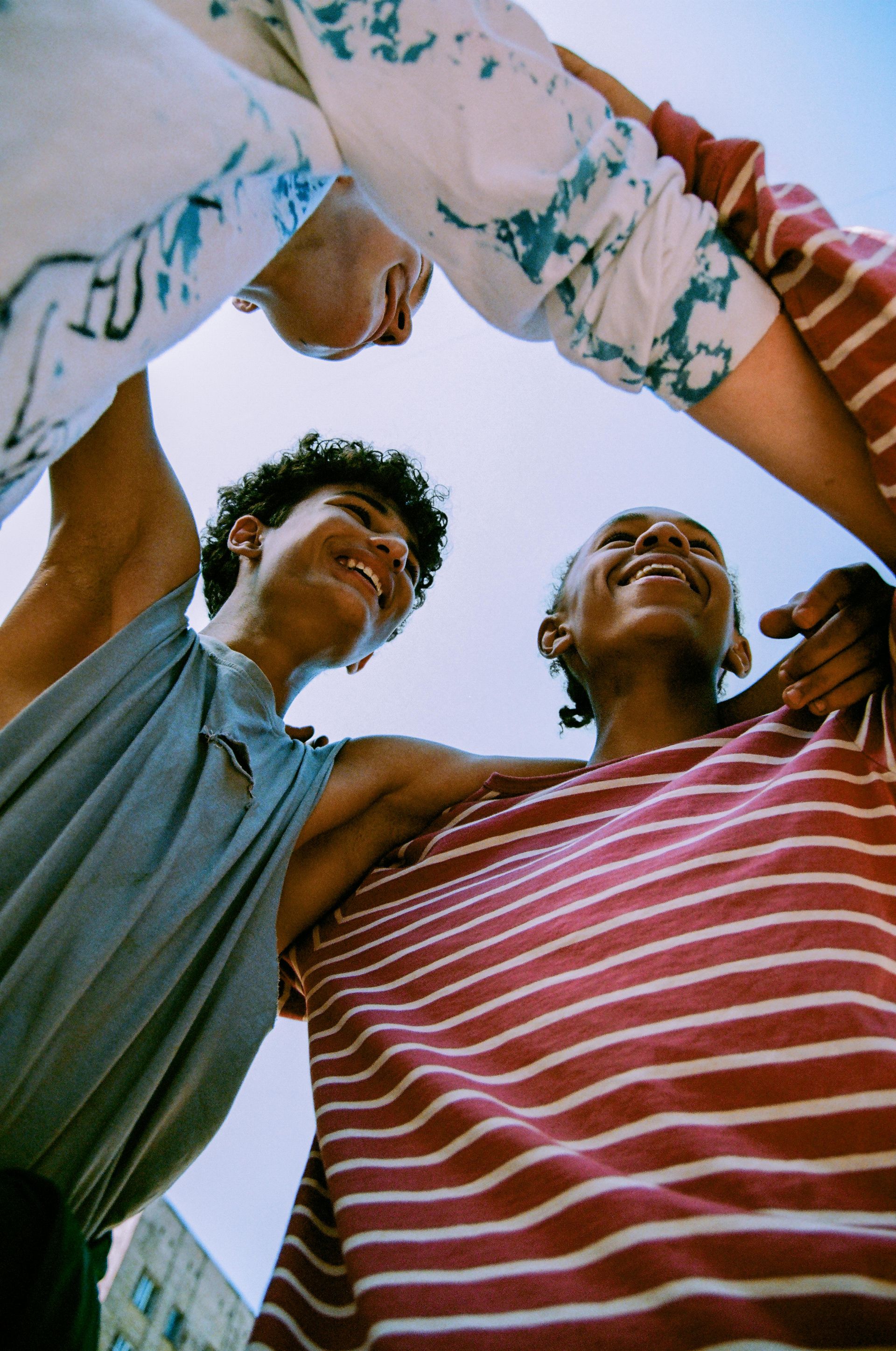 A group of people are standing in a circle with their hands in the air.