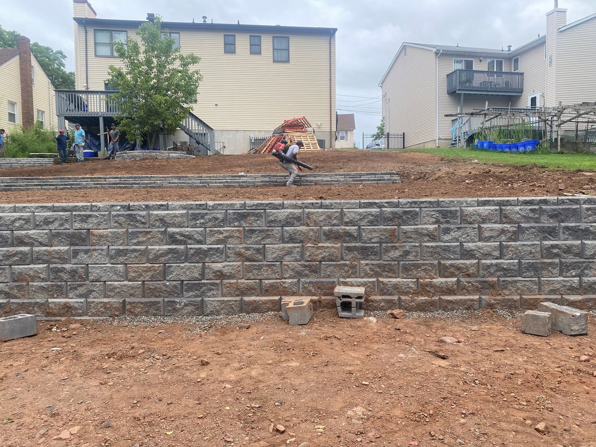 A man installing a stone retaining wall.