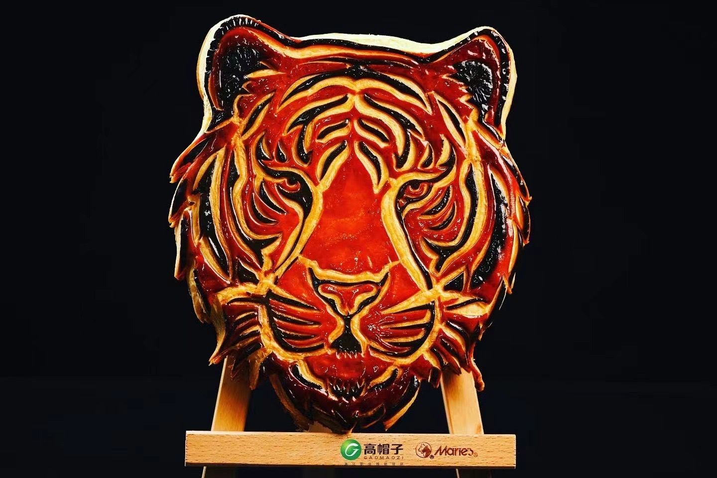 Une statue d'une tête de tigre est assise sur un support en bois.