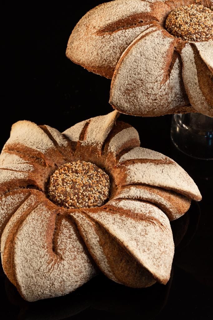 Deux pains en forme de fleur sont posés sur une table.