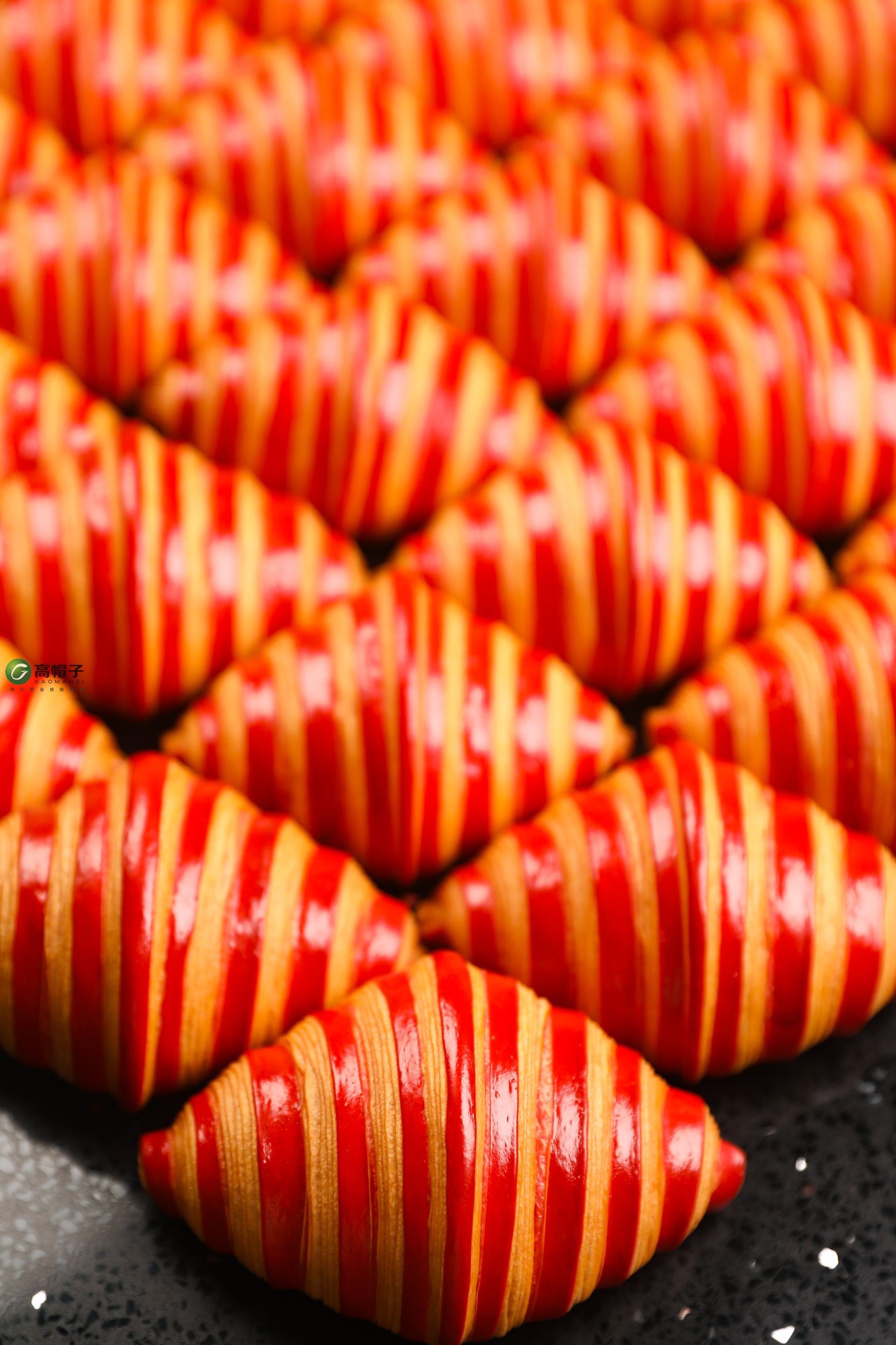 Un tas de perles rayées rouges et jaunes sont posées sur une table.