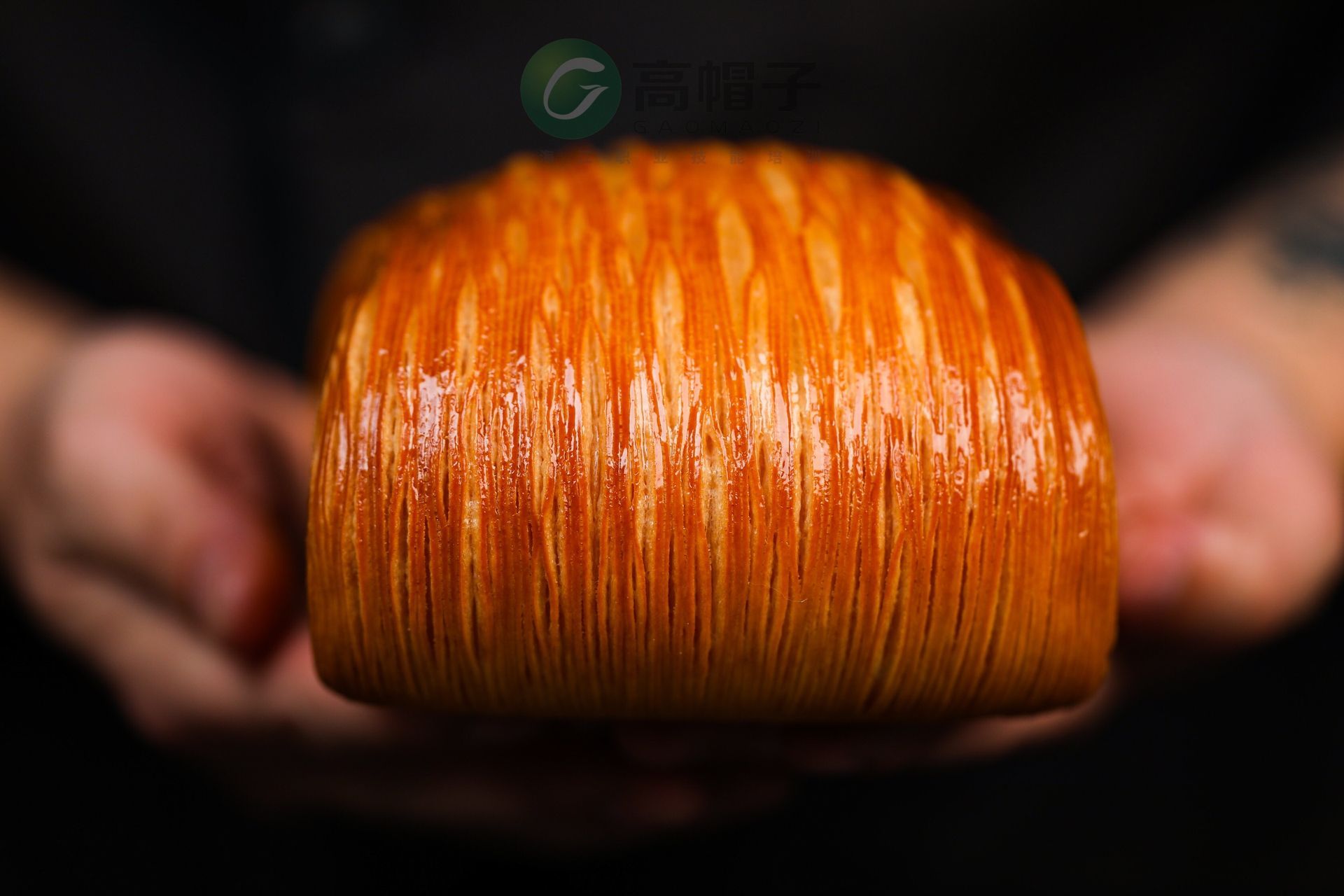 Une personne tient une miche de pain dans ses mains.