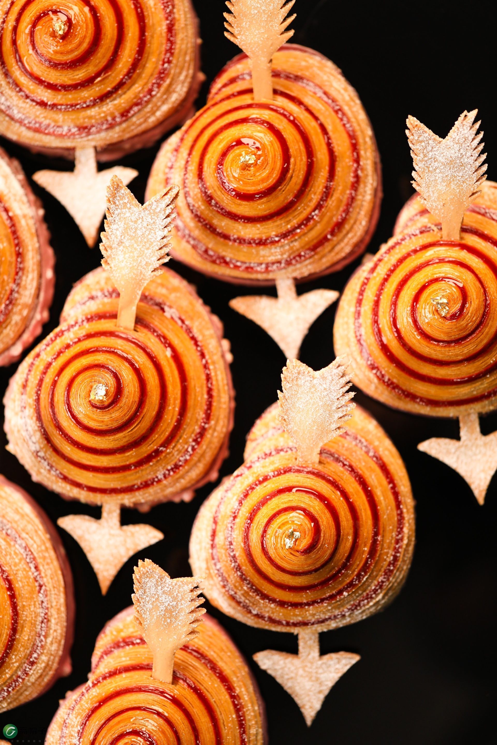 Un tas de cupcakes avec des tourbillons dessus sont posés les uns sur les autres sur une table.