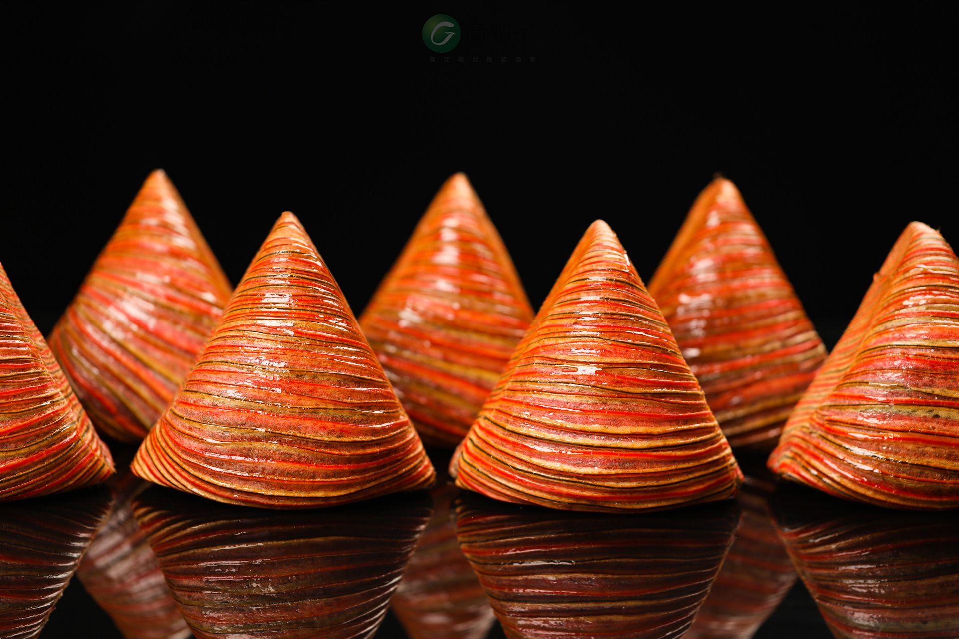 Une rangée de cônes orange sur une surface noire.