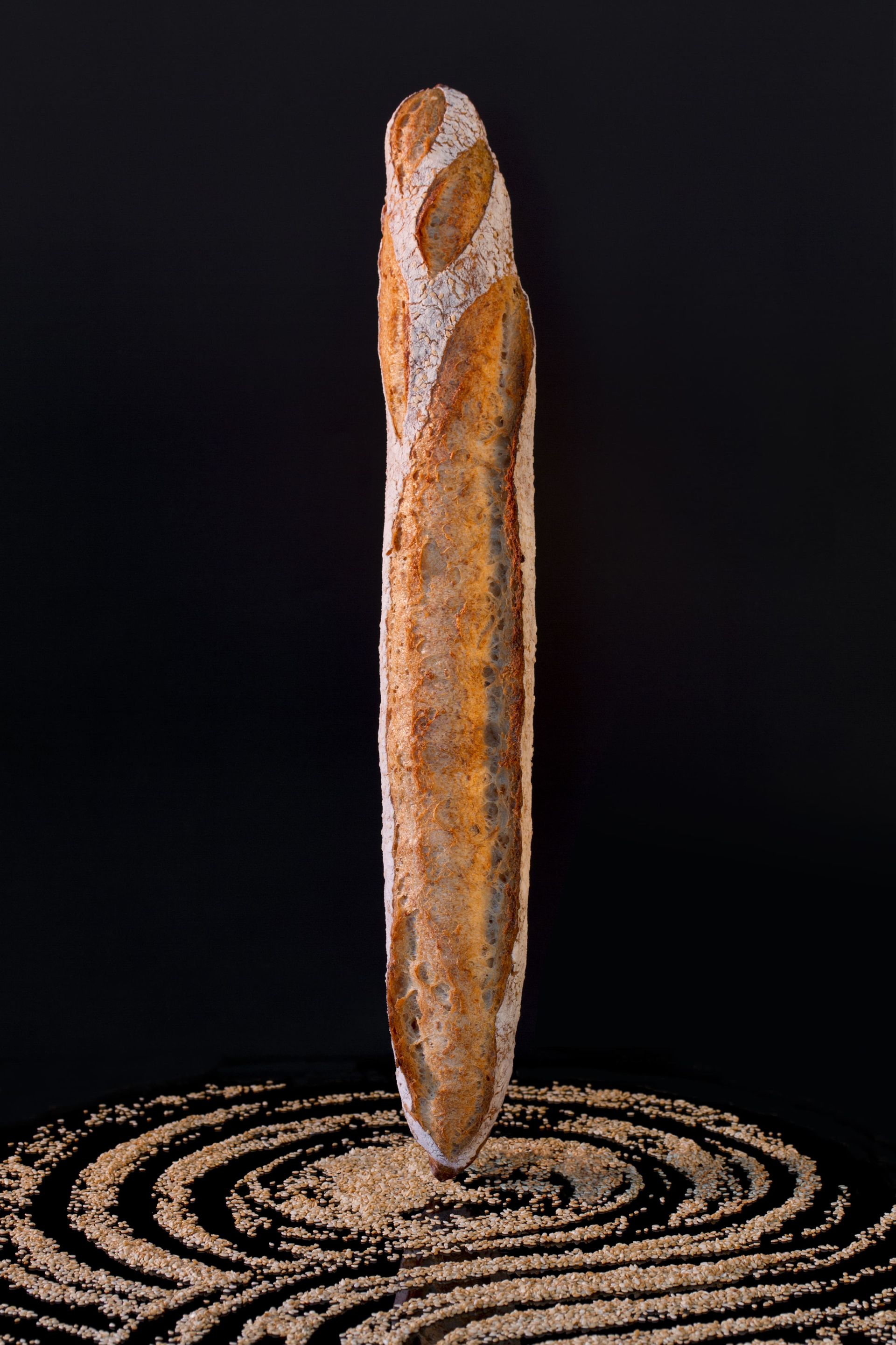 Une miche de pain est posée sur un tas de farine.