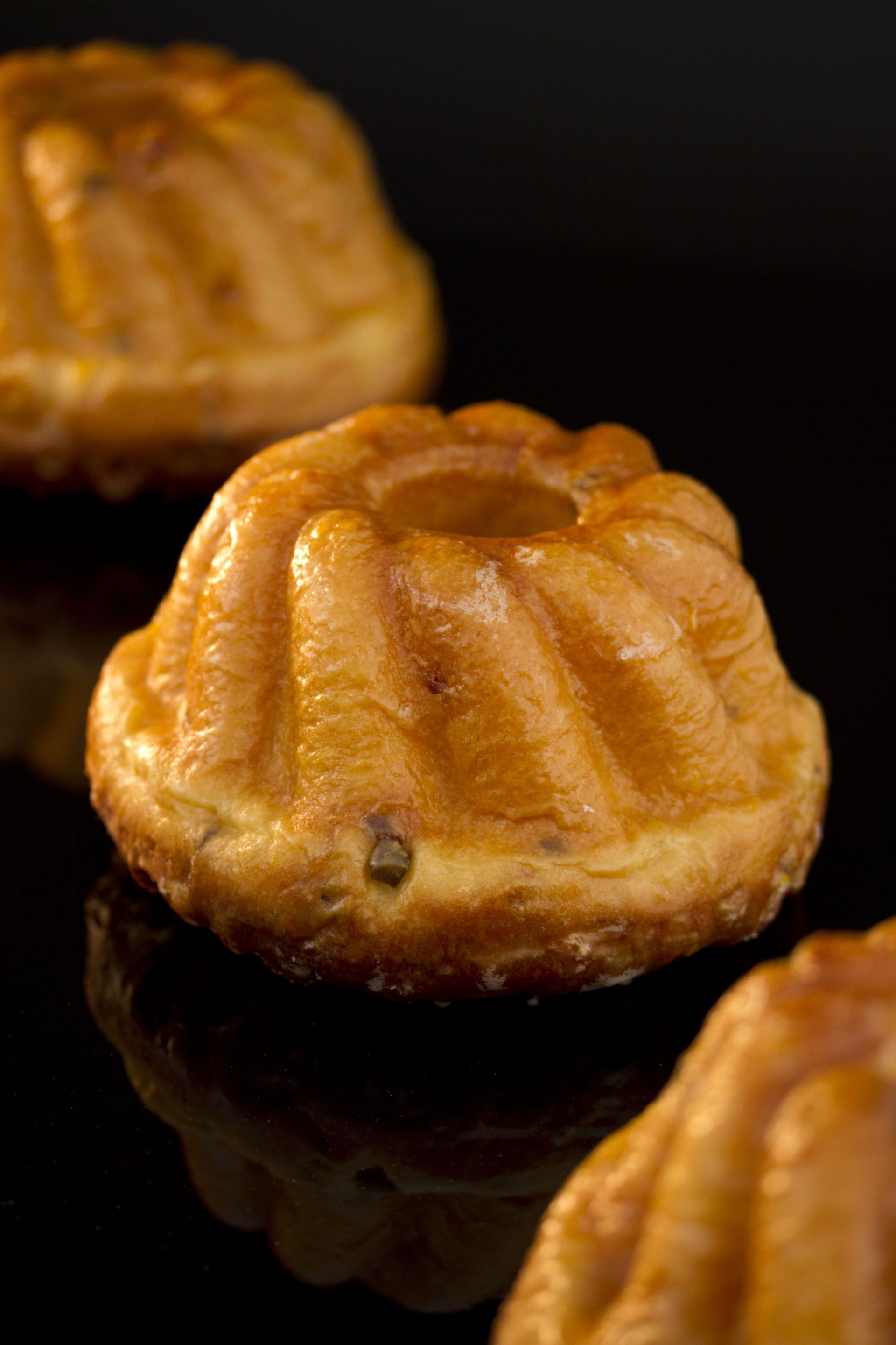 Un gros plan de trois cupcakes sur une surface noire.