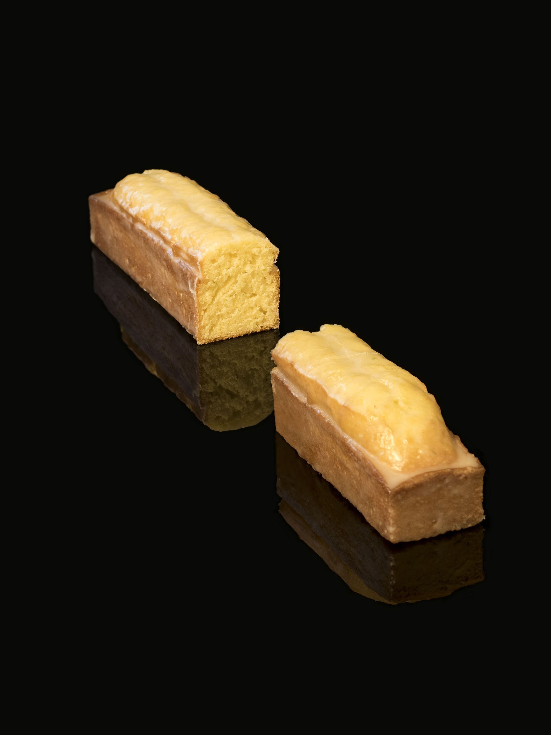 Deux pains de gâteau sont posés sur une surface noire.