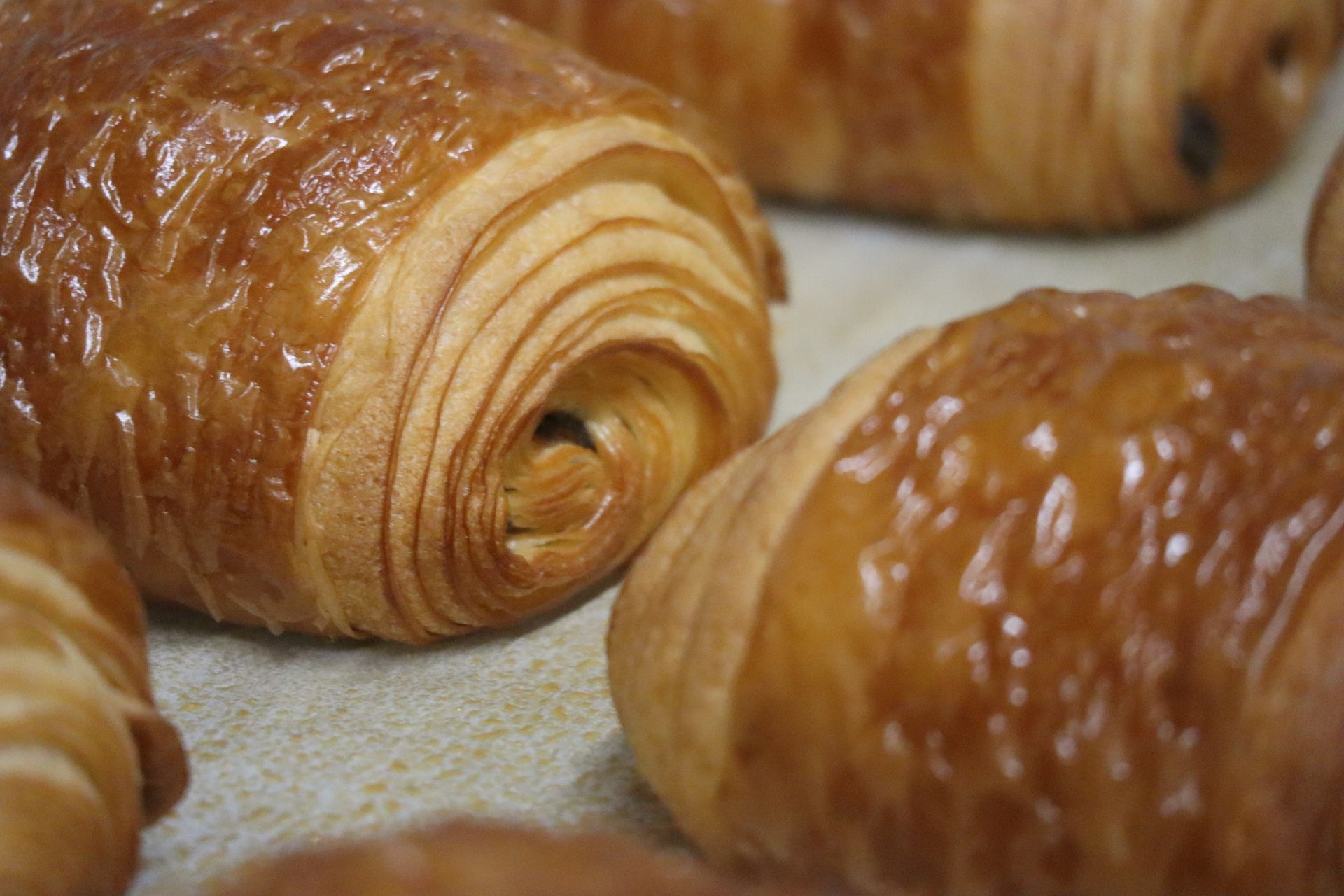 Un tas de croissants au chocolat sont posés sur une table.