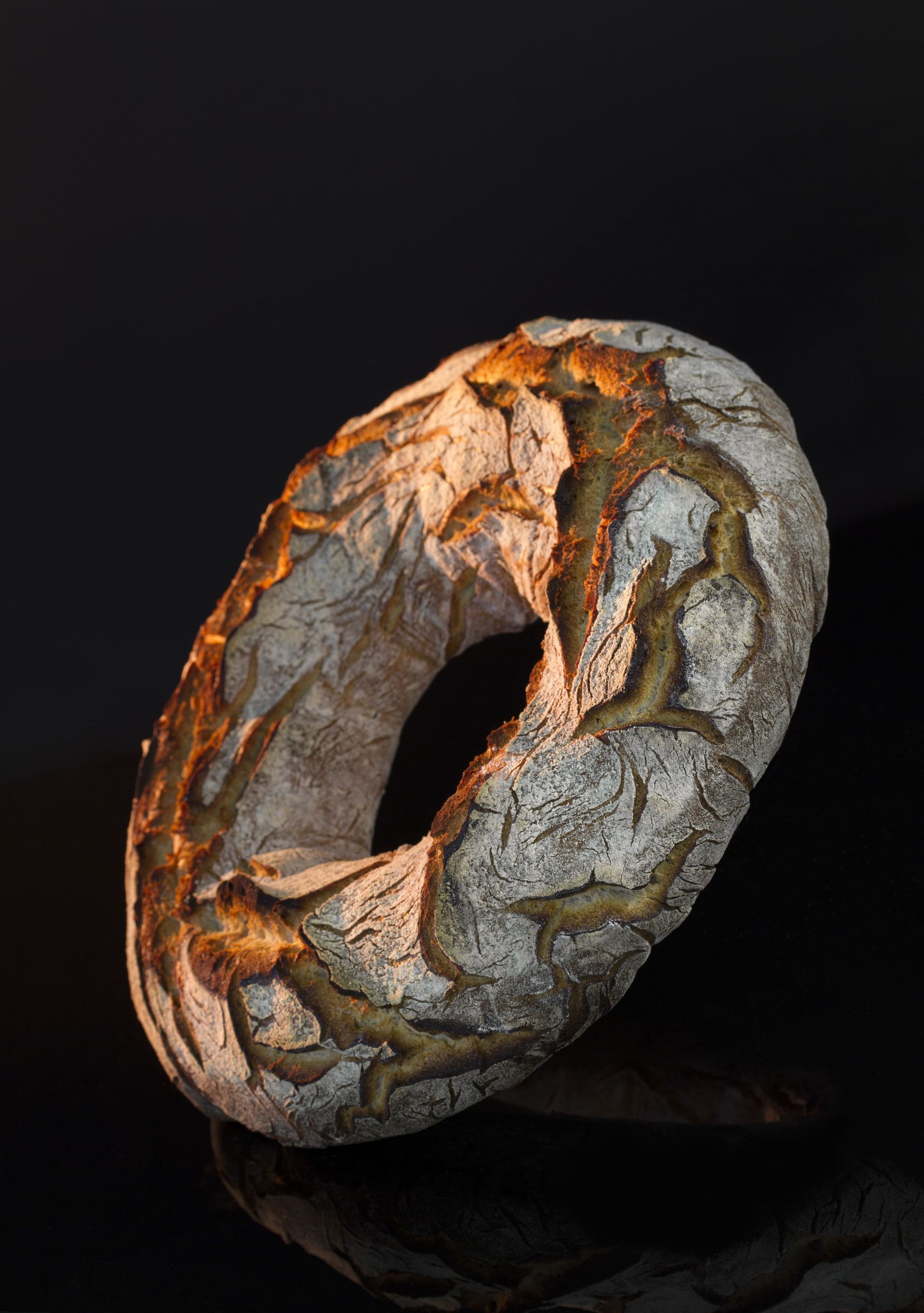 Une miche de pain avec un trou au milieu est posée sur une table.