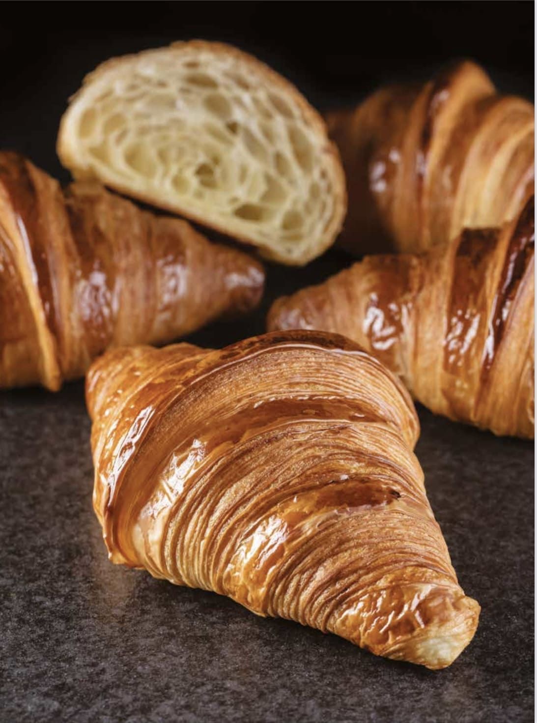 Un gros plan d'un croissant avec une tranche prélevée sur une table.