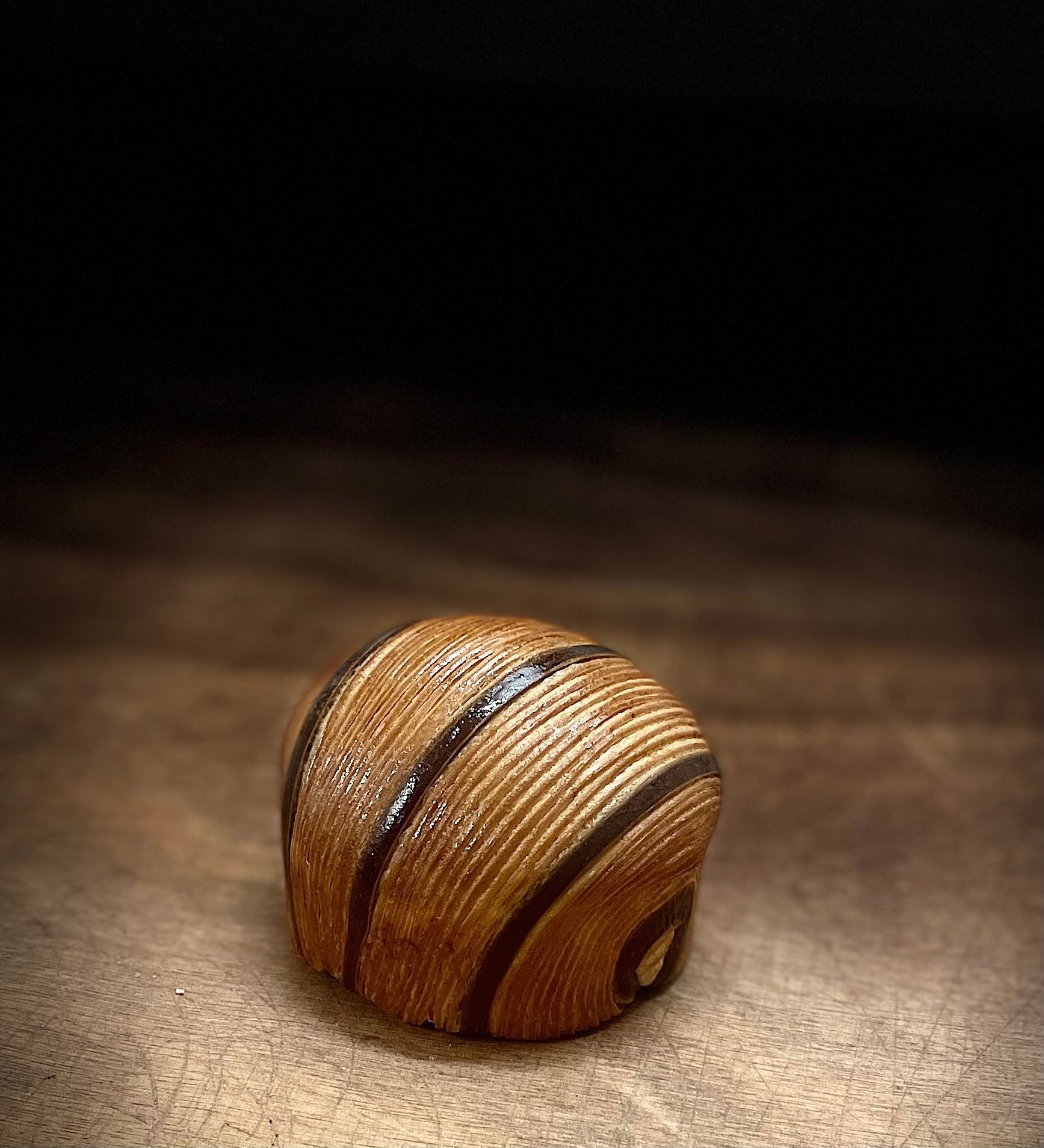 Une petite boule en bois est posée sur une table en bois.