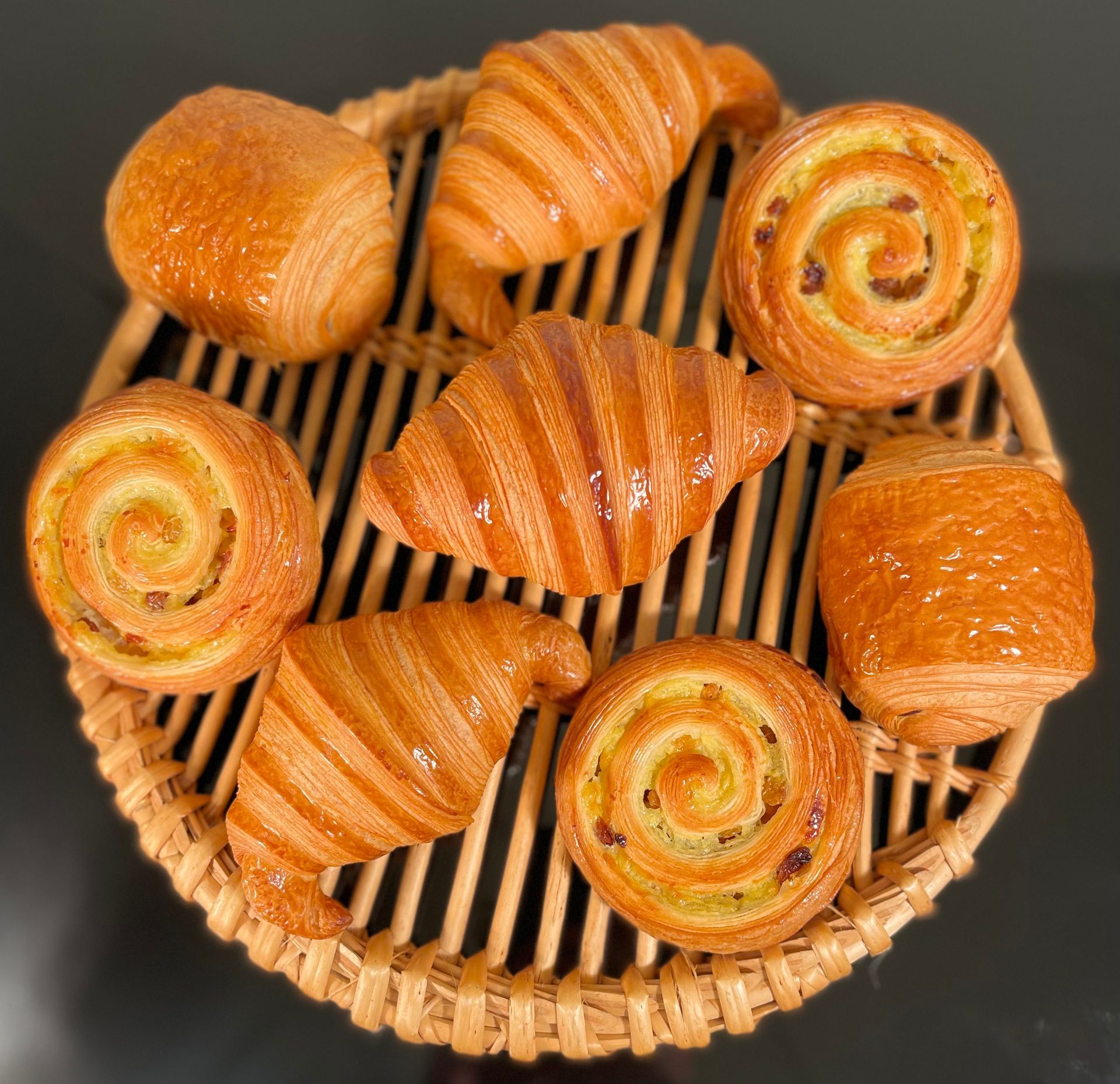 Un panier en osier rempli de croissants et de viennoiseries