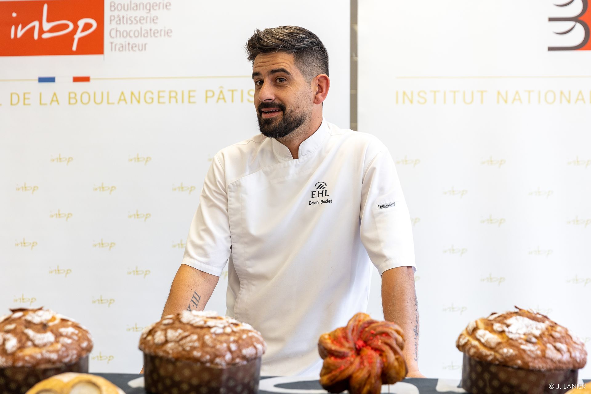 Un homme se tient devant une table avec du pain dessus.