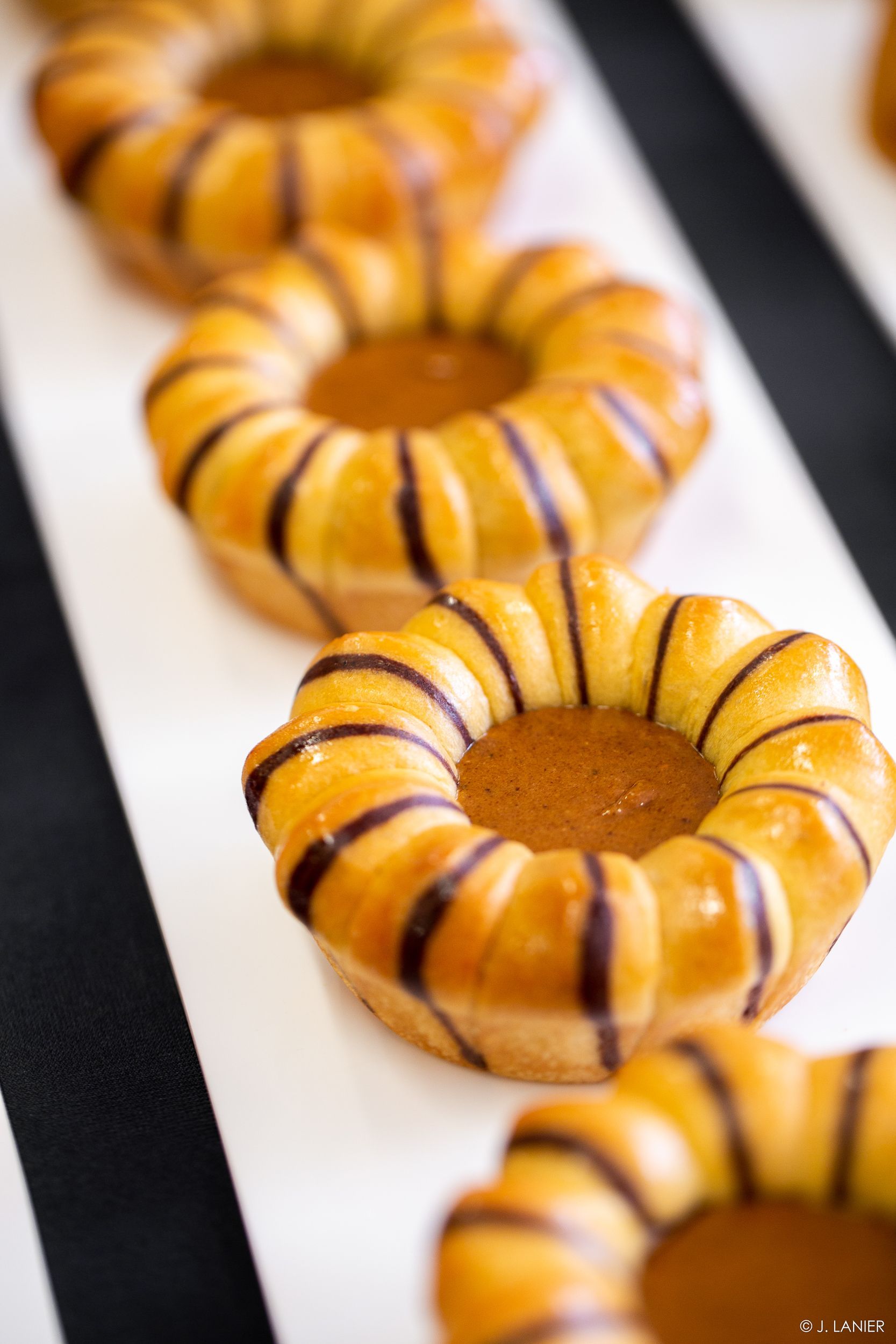 Une rangée de beignets sur une nappe rayée