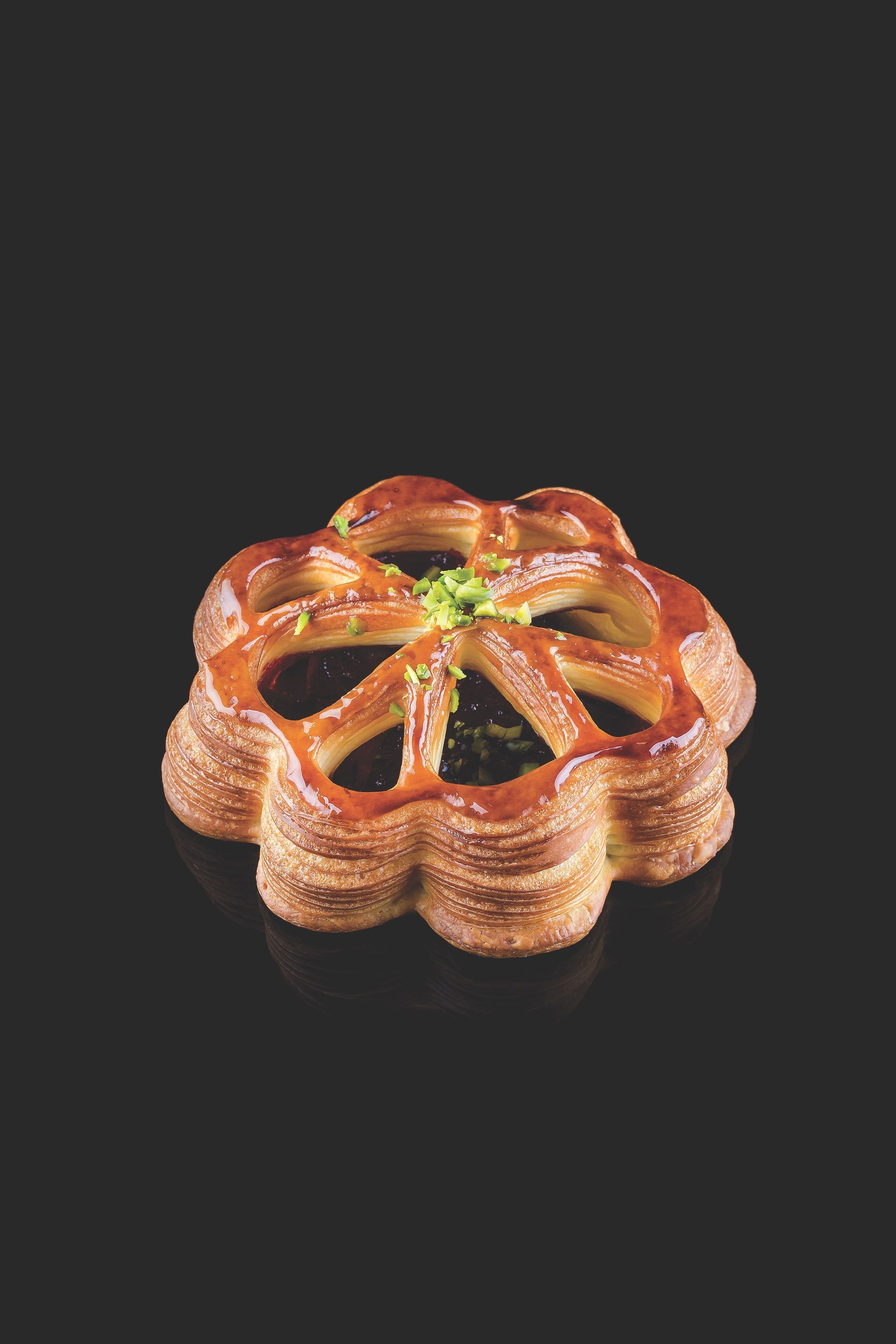 Une pâtisserie en forme de fleur sur fond noir.