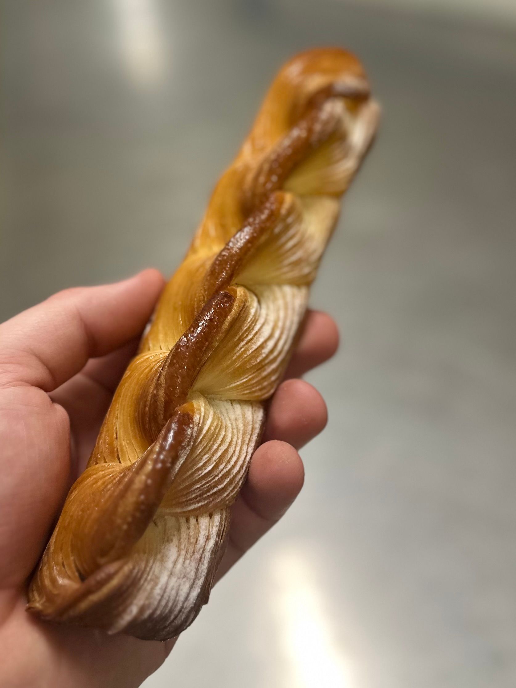 Une personne tient une miche de pain dans sa main